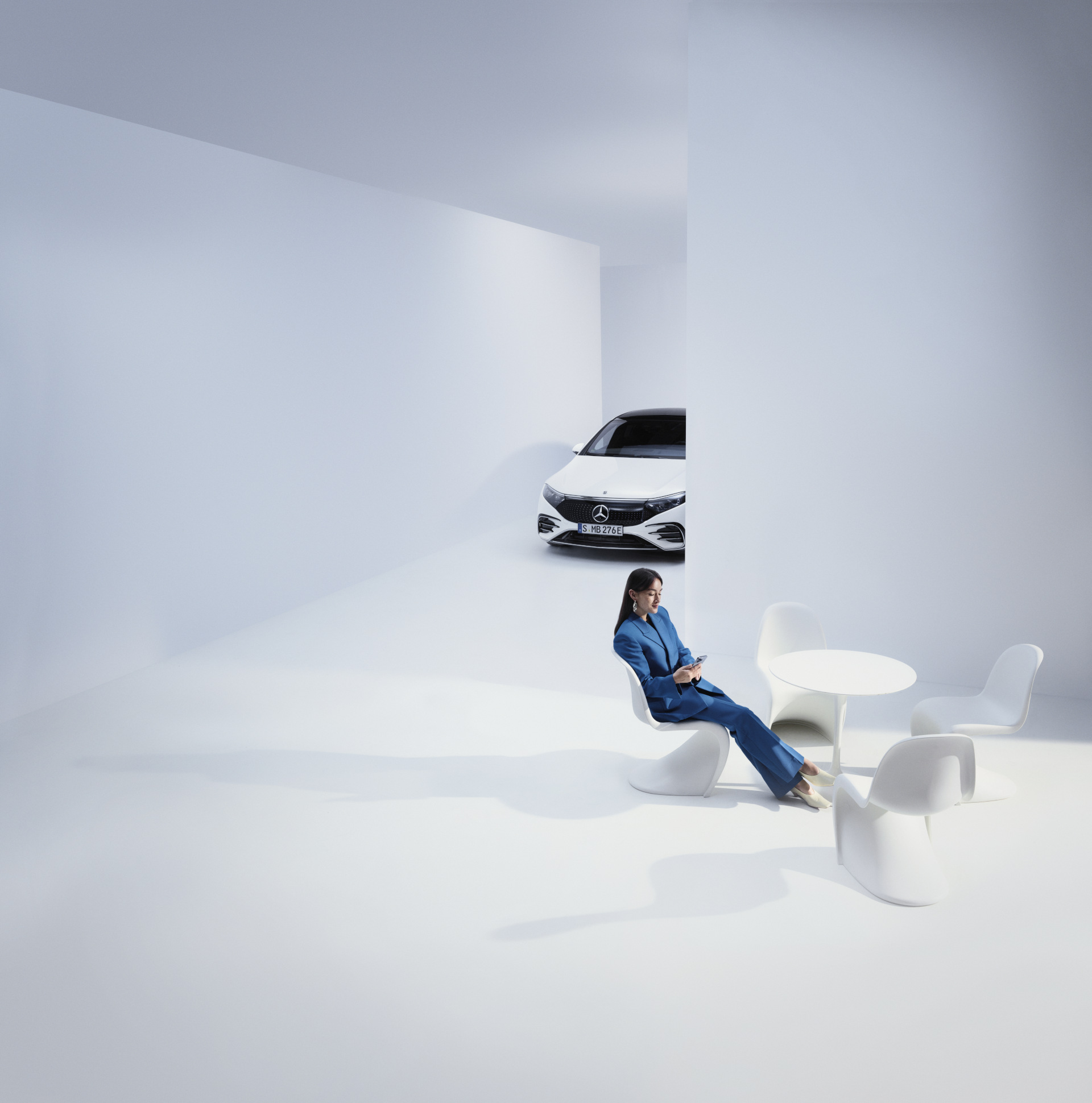 Campañas de recall y medidas de servicio | Mercedes-Benz Una persona sentada junto al vehículo Mercedes-Benz mirando el teléfono móvil.
