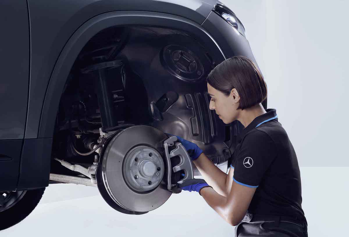 Recambios | Mercedes-Benz Una mujer revisando los frenos de un Mercedes-Benz