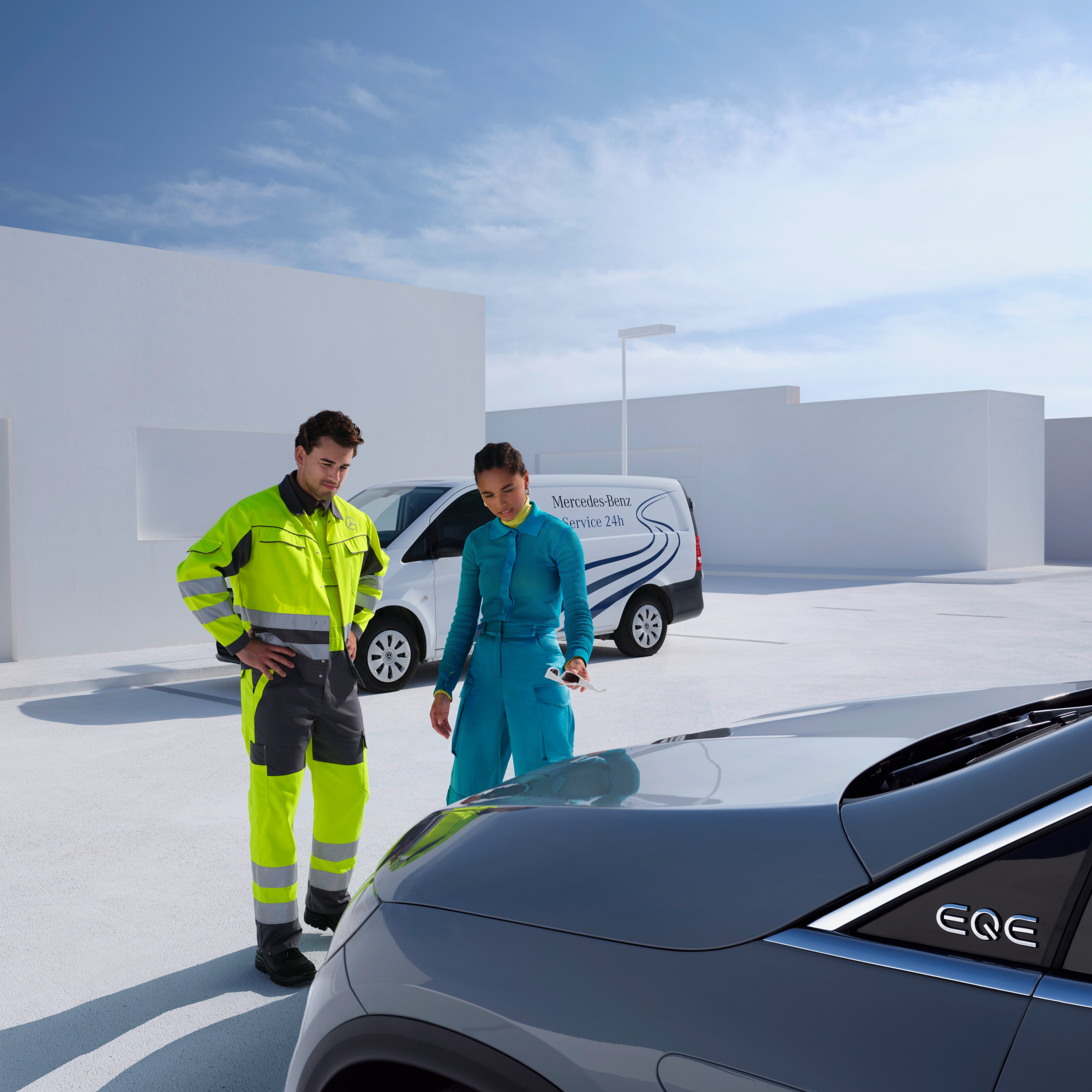 Un técnico del equipo de Servicio Mercedes-Benz junto con otra persona mirando un Mercedes-Benz.