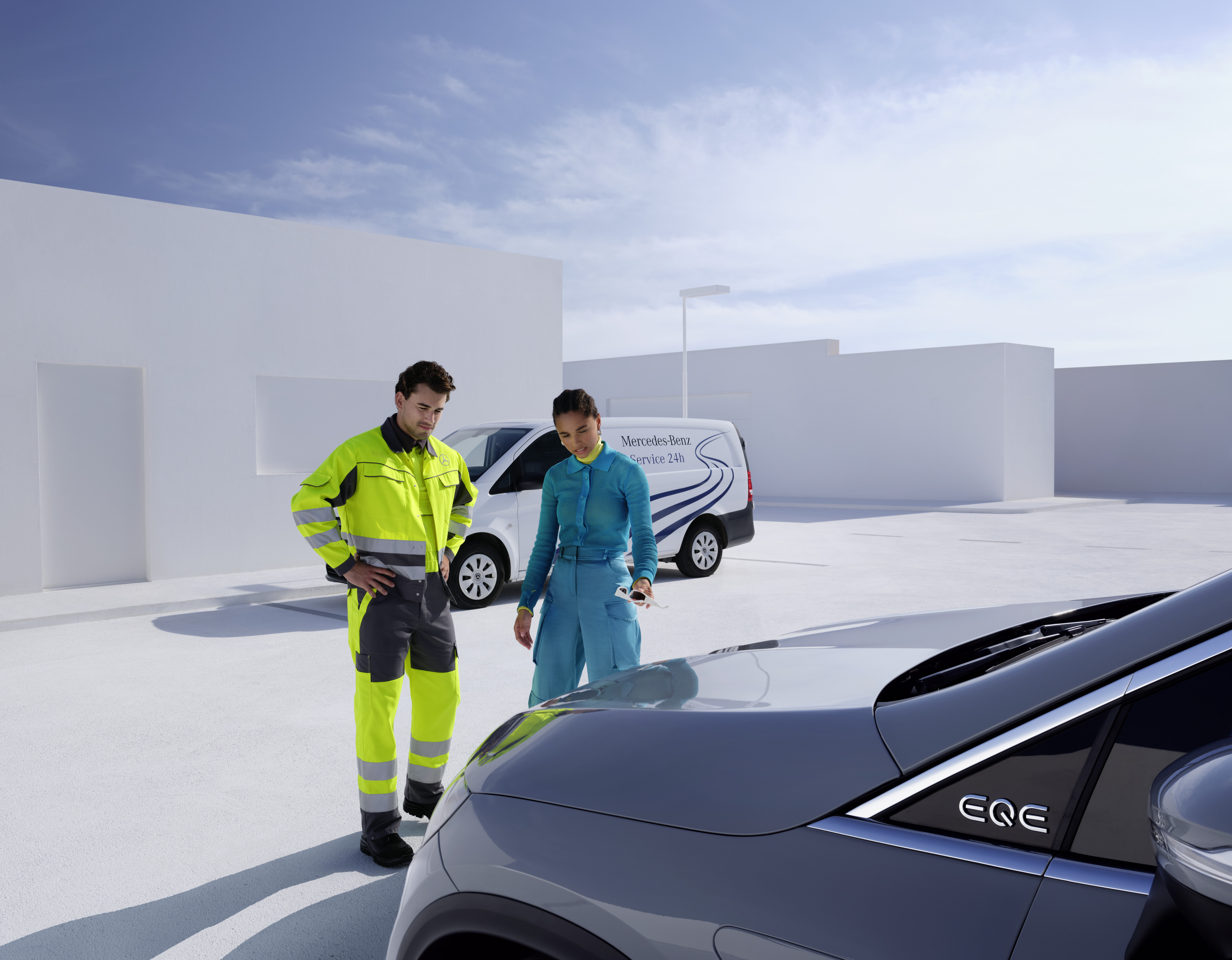 Asistencia en carretera | Mercedes-Benz Un técnico del equipo de Servicio Mercedes-Benz junto con otra persona mirando un Mercedes-Benz.