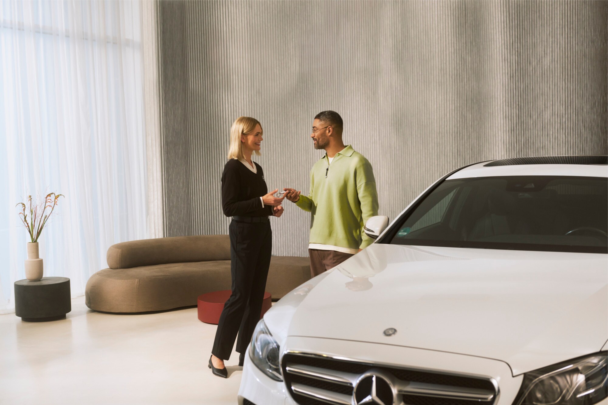 Un asesor de Mercedes-Benz entregando las llaves del vehículo a un cliente.