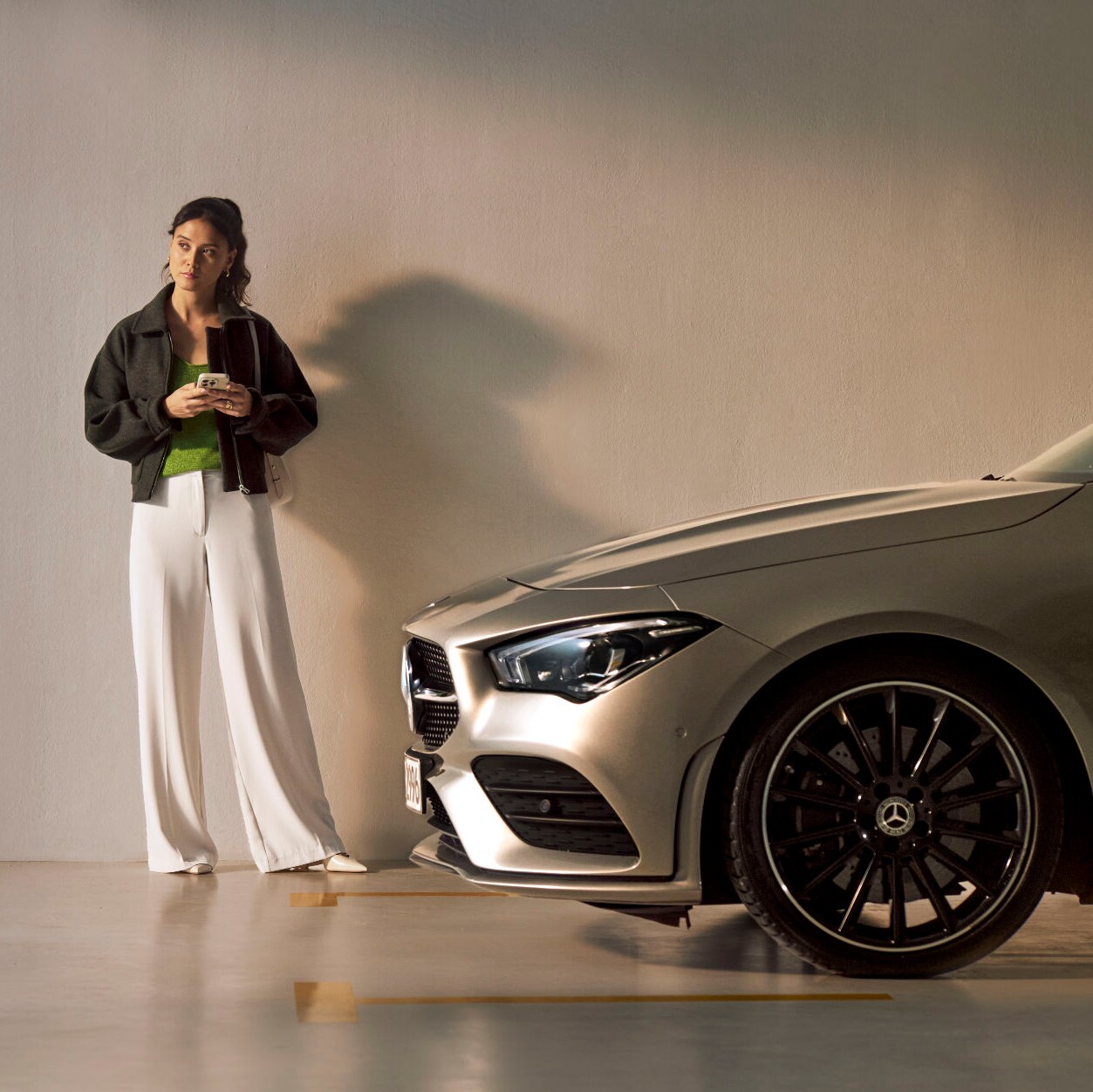 Una mujer delante de un vehículo Mercedes-Benz.