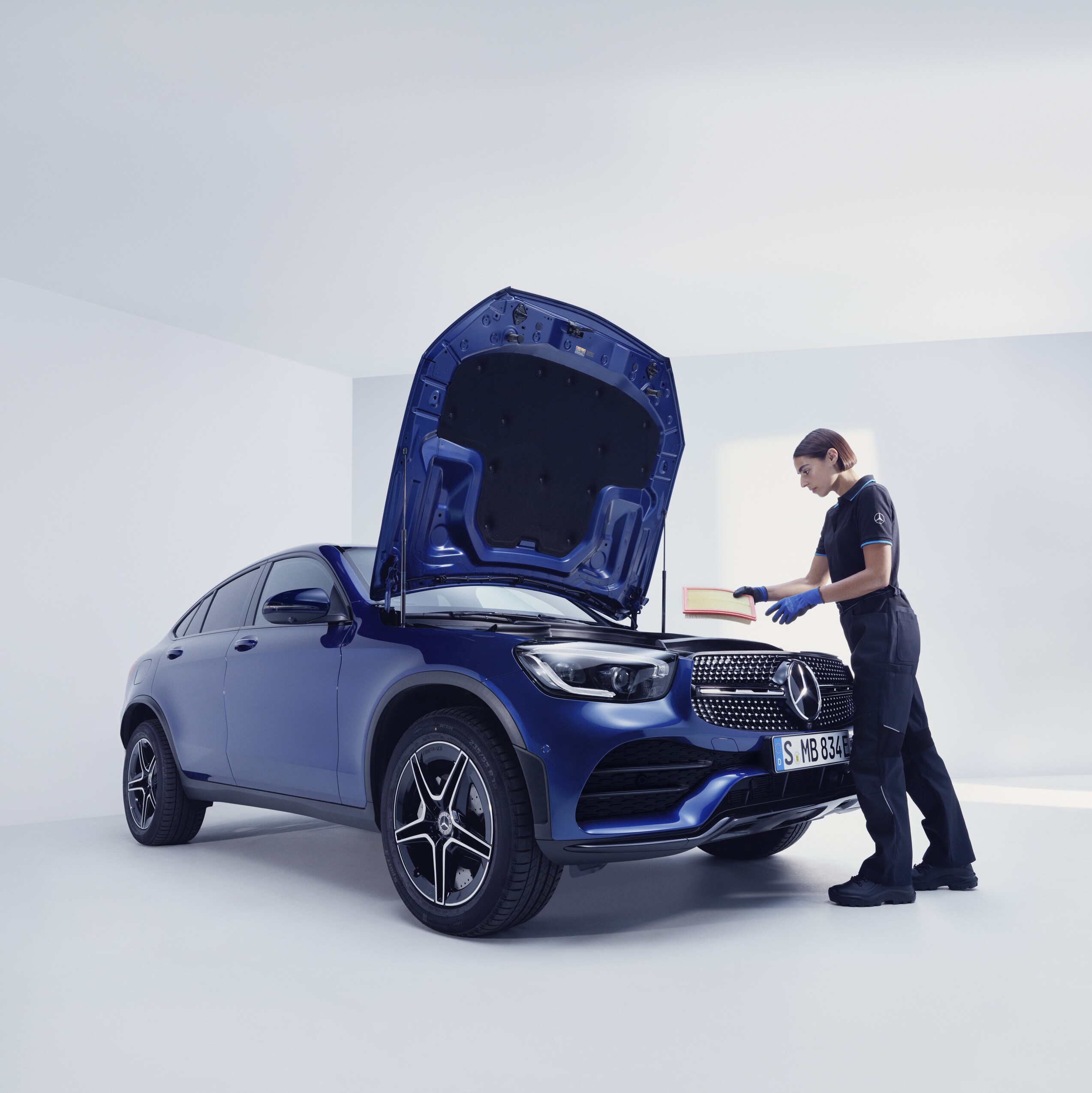 Un mecánico de Mercedes-Benz examinando un Mercedes-Benz.