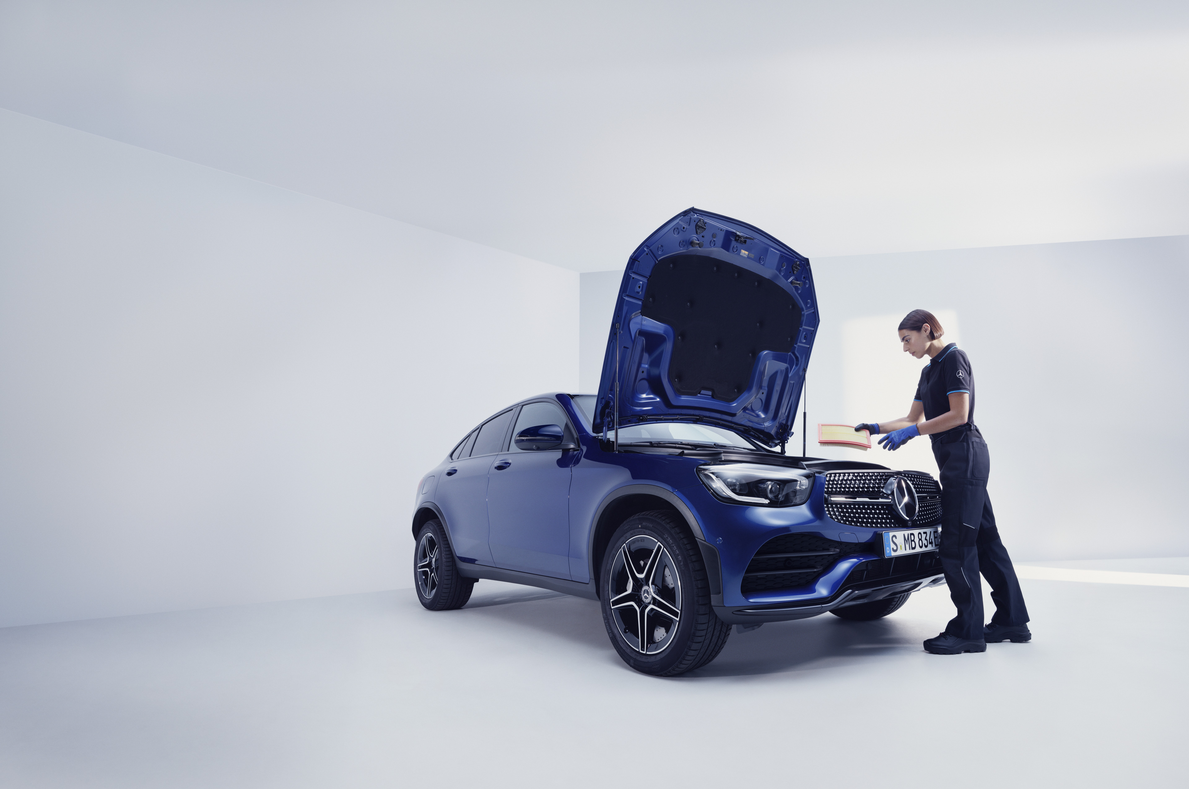 Servicios de mantenimiento | Mercedes-Benz Un mecánico de Mercedes-Benz examinando un Mercedes-Benz.