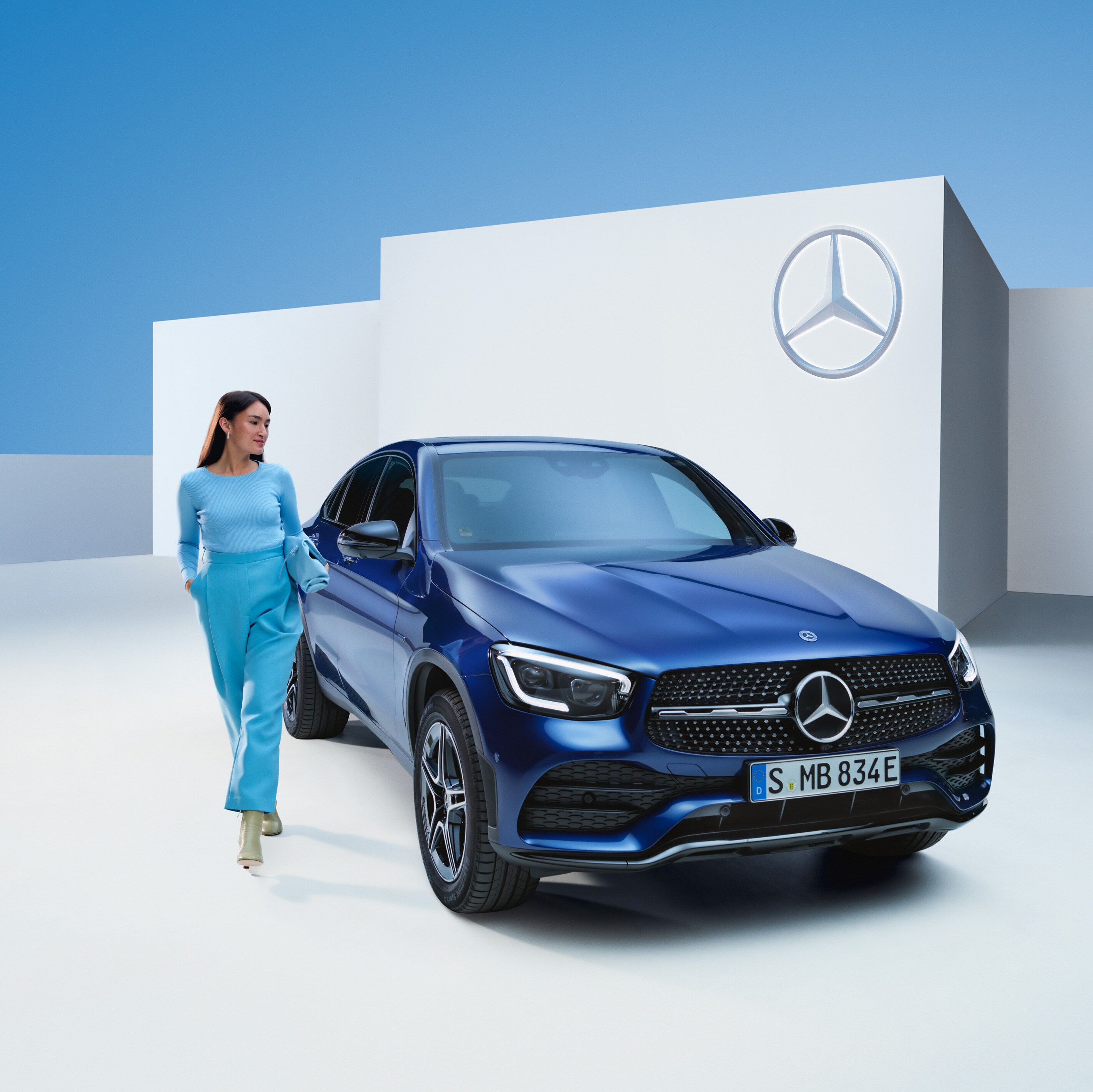 Una persona caminando junto a un vehículo Mercedes-Benz.