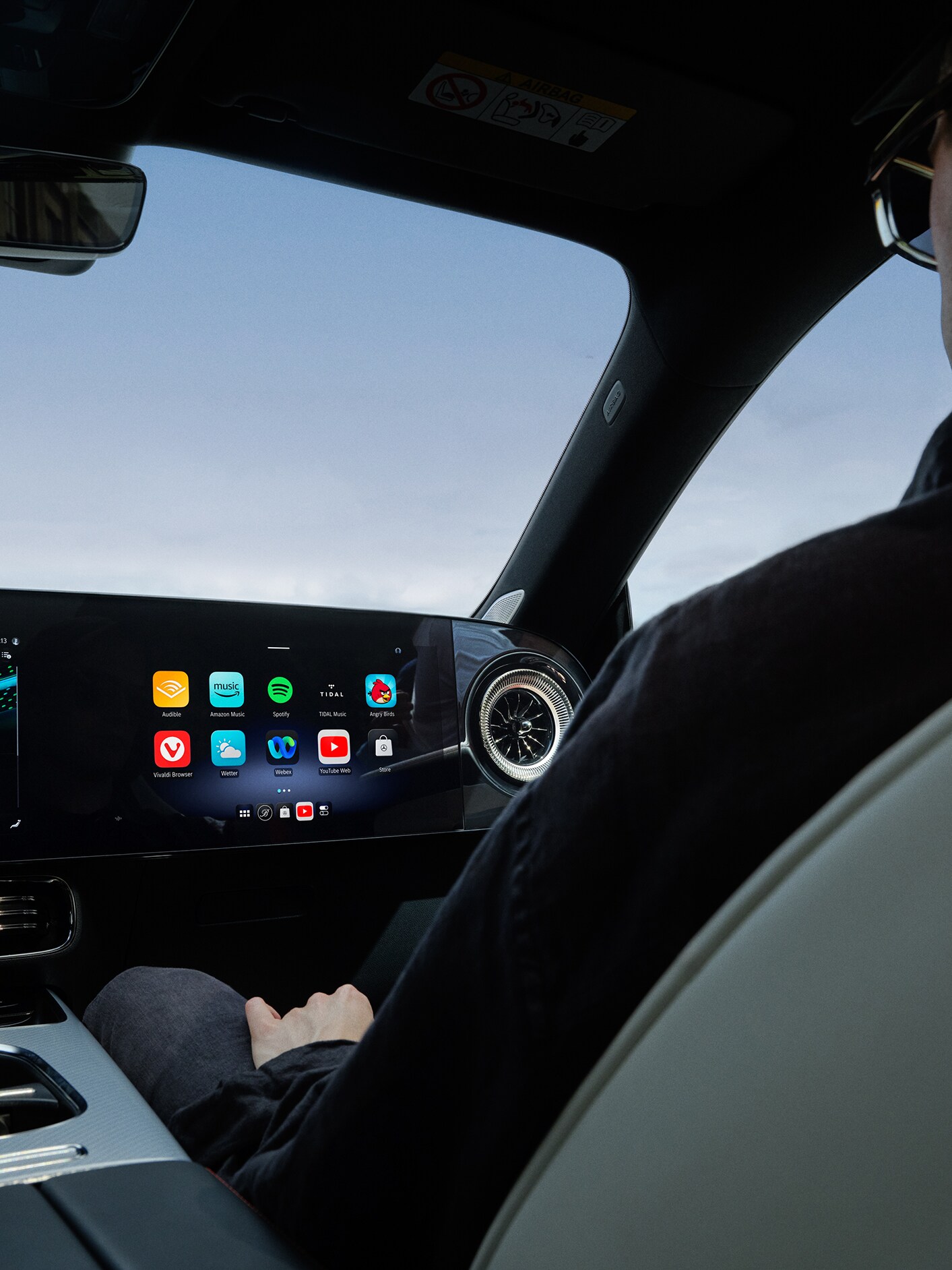 Vista del interior mostrando el puesto de conducción de un Mercedes-Benz con el sistema multimedia MBUX.