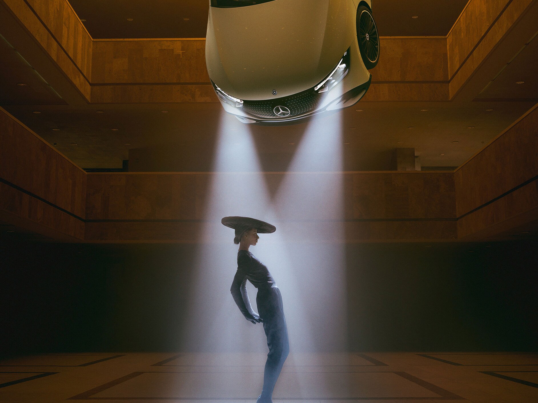 Una persona bailando a la luz de los faros de un coche flotante de Mercedes-Benz.