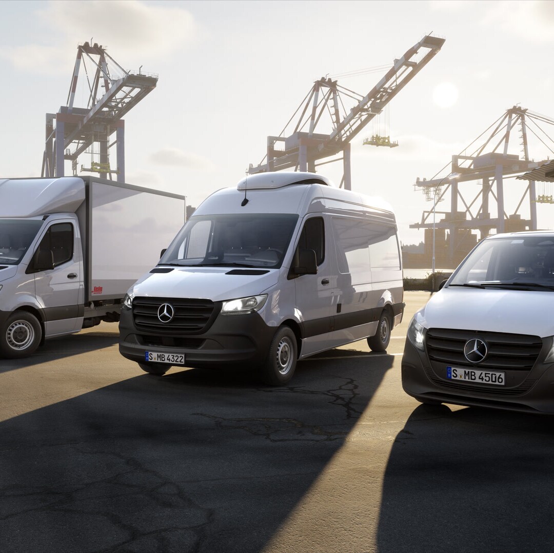 Tres furgonetas Mercedes-Benz situadas en una terminal de contenedores frente a grúas del puerto. Se pueden ver un vehículo con estructura de carrocería, un furgón y una furgoneta compacta en un entorno logístico.