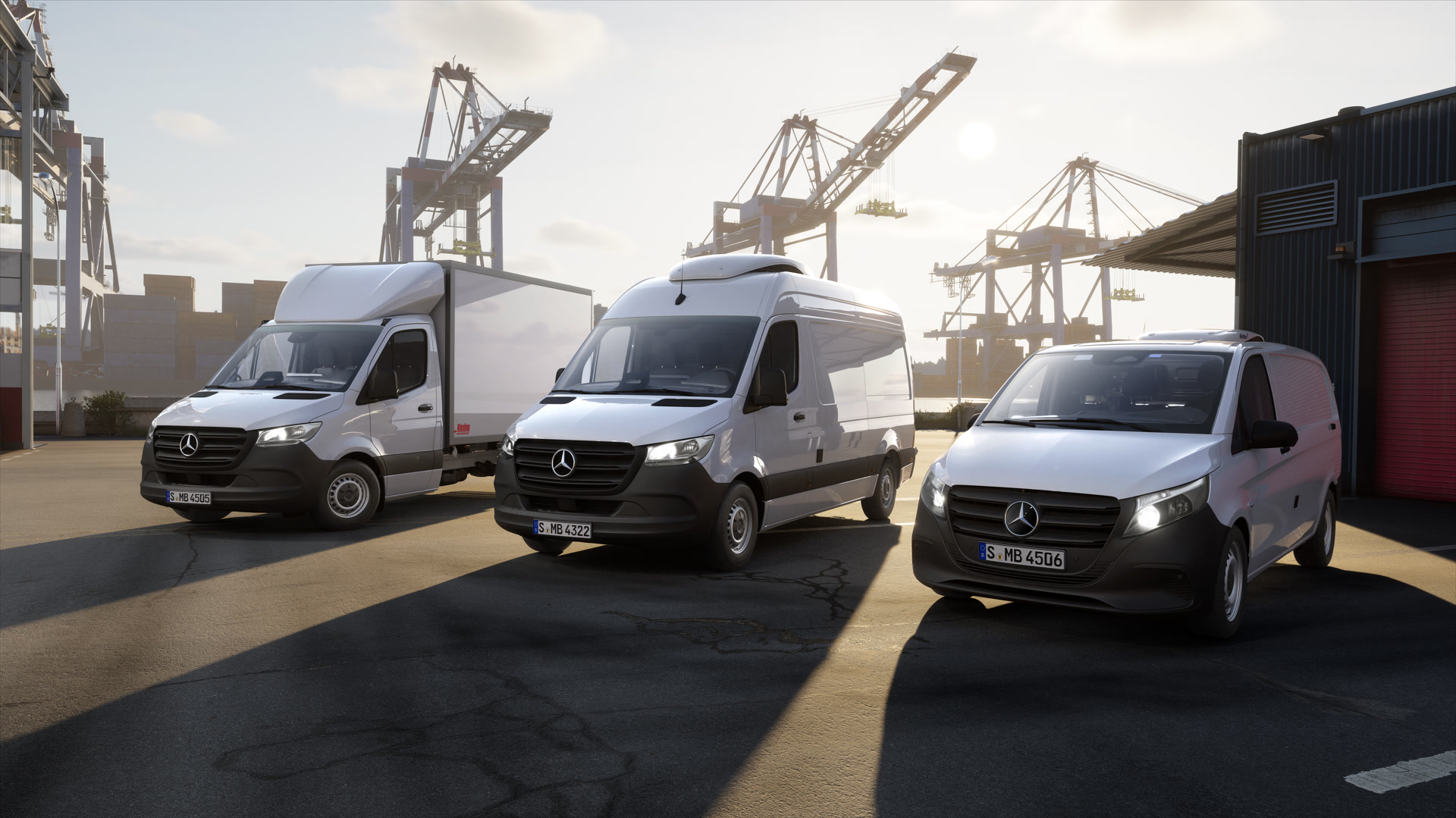Mercedes-Benz VanSolution de fábrica para soluciones profesionales de carrocerías y modificaciones. Tres furgonetas Mercedes-Benz situadas en una terminal de contenedores frente a grúas del puerto. Se pueden ver un vehículo con estructura de carrocería, un furgón y una furgoneta compacta en un entorno logístico.