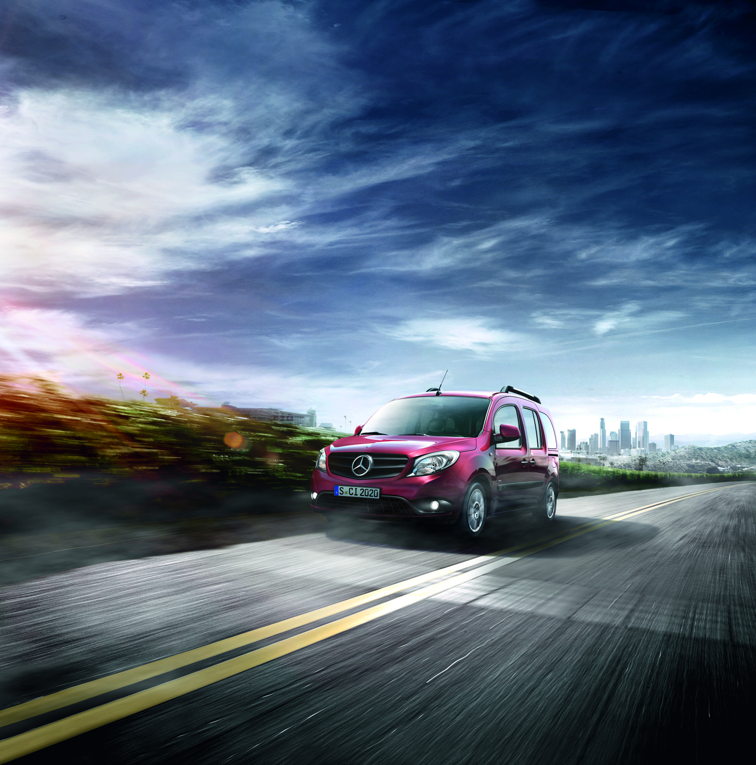 Explora el dinámico furgón Citan de Mercedes-Benz Mercedes-Benz Citan rojo transitando por una carretera con vistas panorámicas con el horizonte de la ciudad de fondo