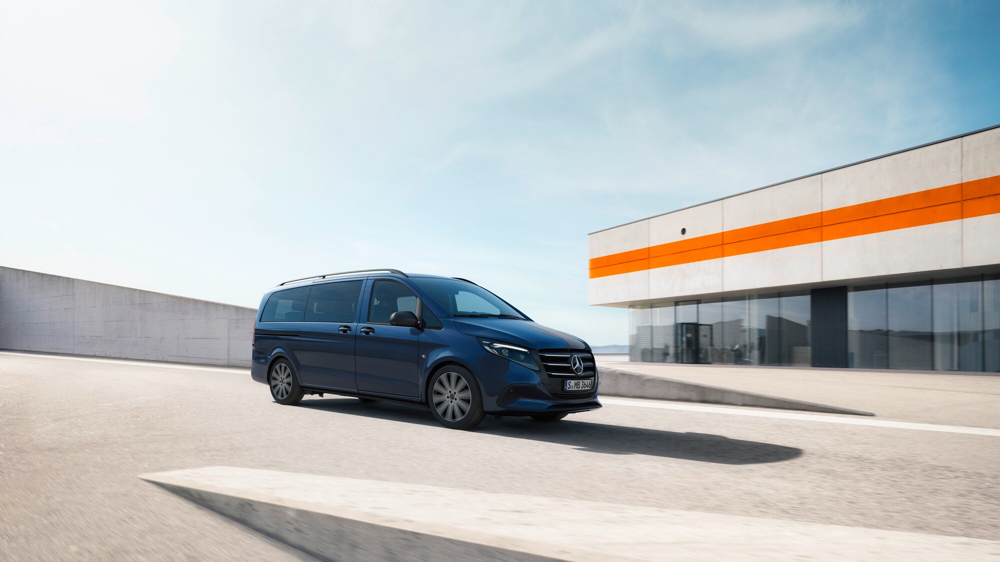 Furgón Mercedes-Benz Clase V pasando frente a un moderno edificio
