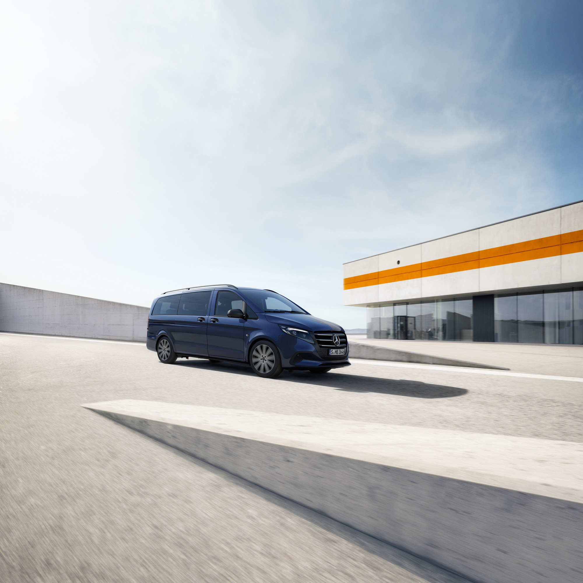 Elegante furgón Mercedes-Benz Clase V Furgón Mercedes-Benz Clase V pasando frente a un moderno edificio