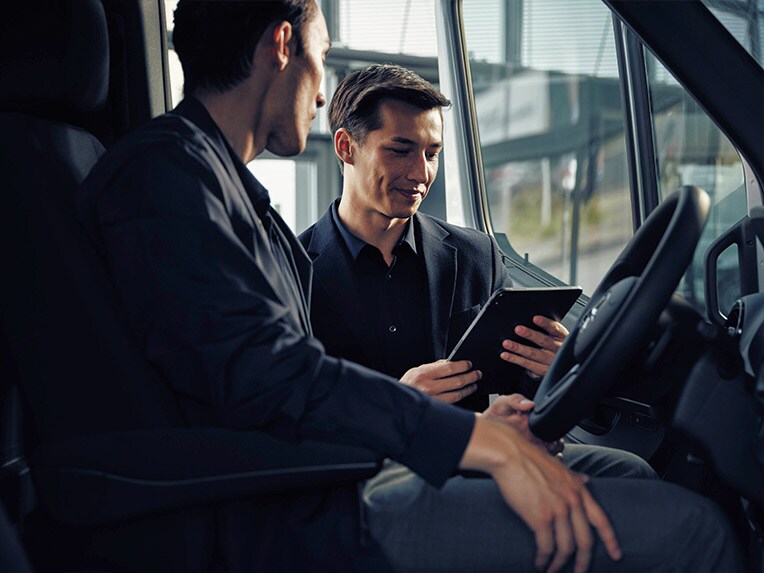 Hombre sentado en la Mercedes-Benz eSprinter hablando con un vendedor