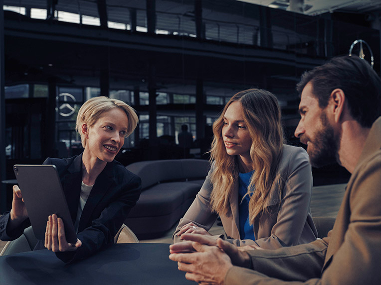 Servicios financieros | Furgonetas Mercedes-Benz Un empleado de Mercedes-Benz atiende una llamada en un taller con una furgoneta elevándose.