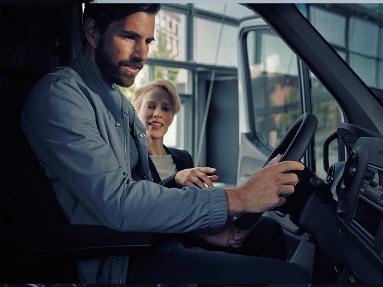 Hombre sentado en la Mercedes-Benz eSprinter hablando con un vendedor