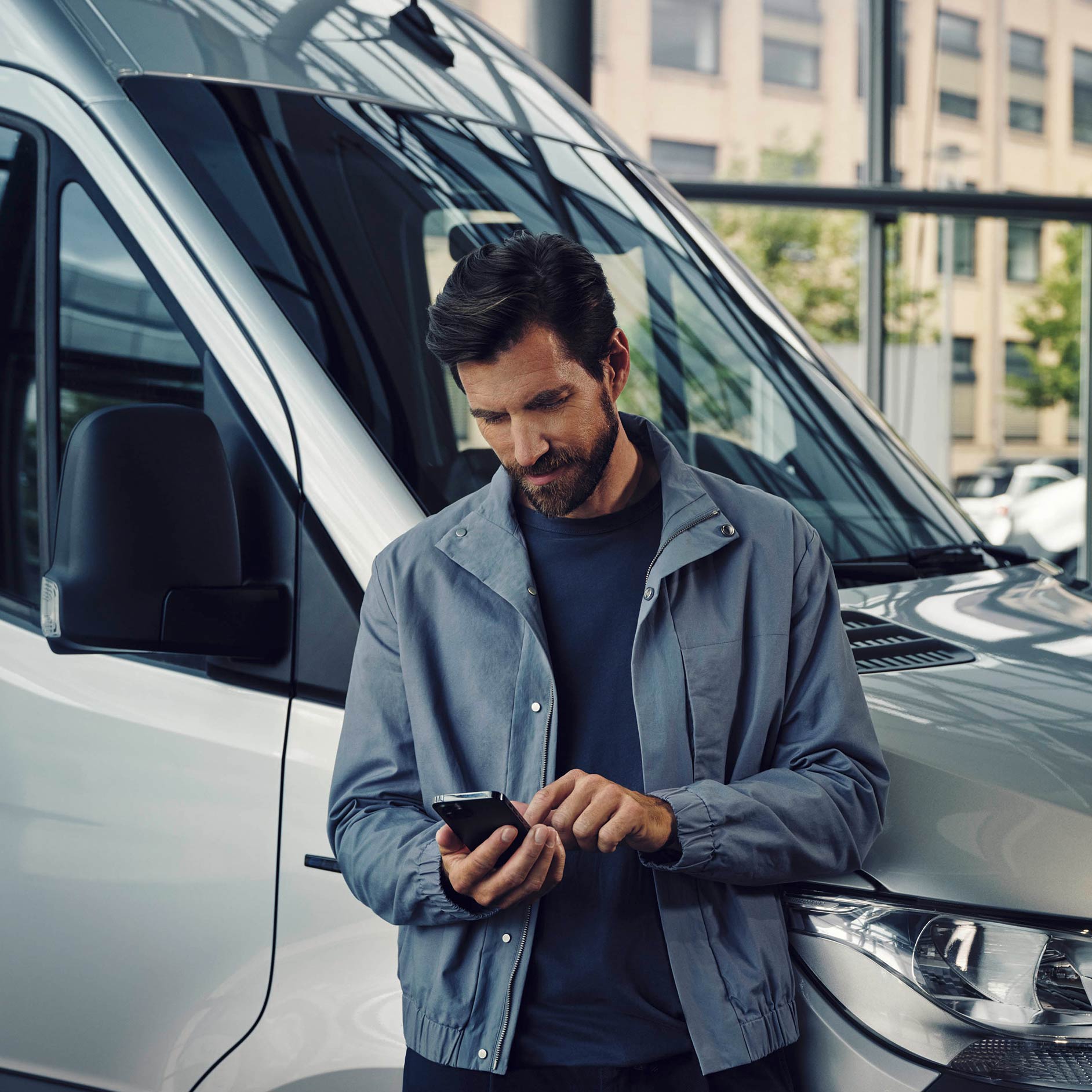 MyChoice | Servicios financieros | Furgonetas Mercedes-Benz Un hombre está de pie hablando por teléfono junto a una furgoneta Mercedes-Benz eSprinter blanca