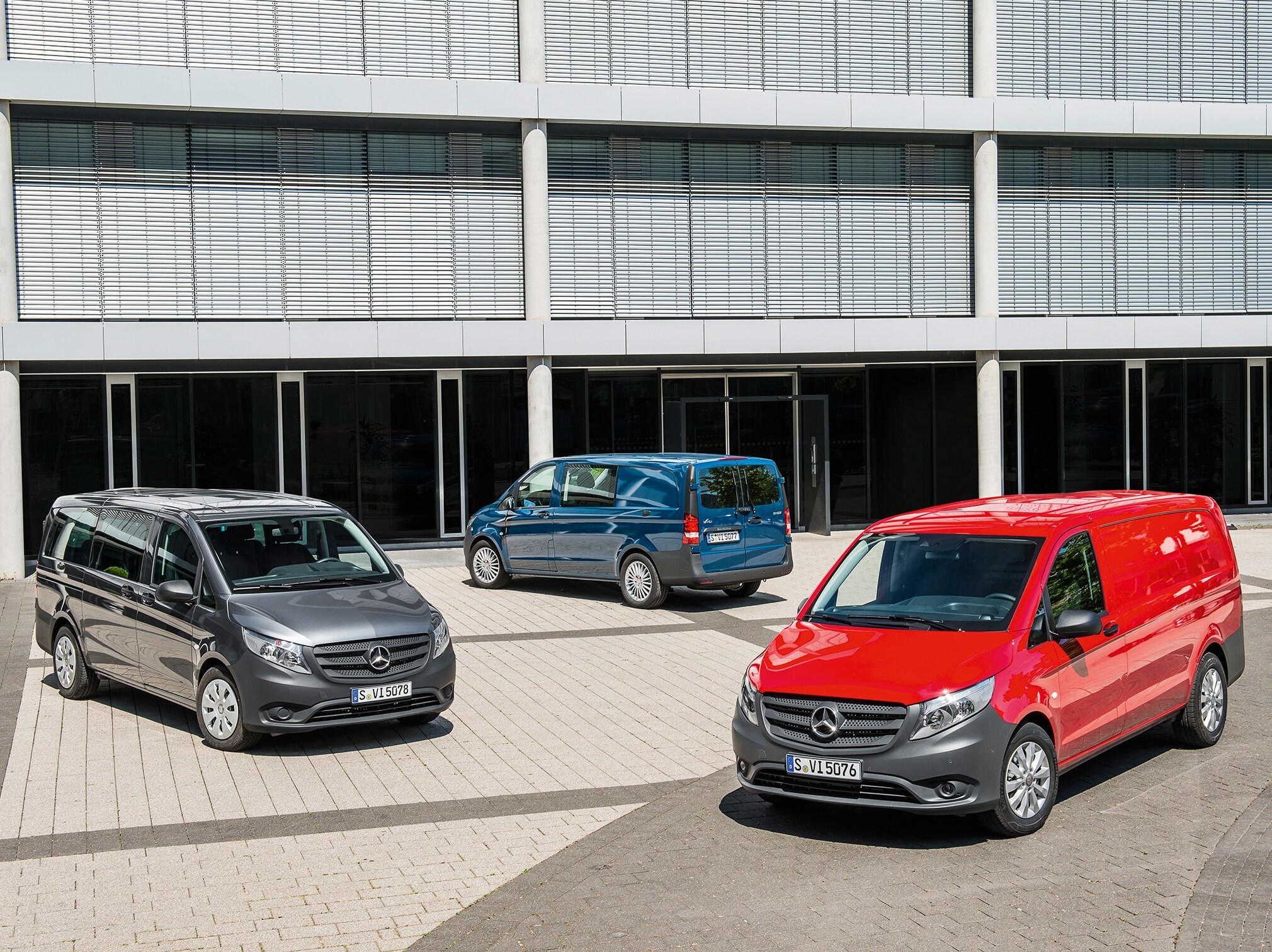Varias furgonetas Mercedes-Benz Vito aparcadas frente a un moderno edificio de oficinas
