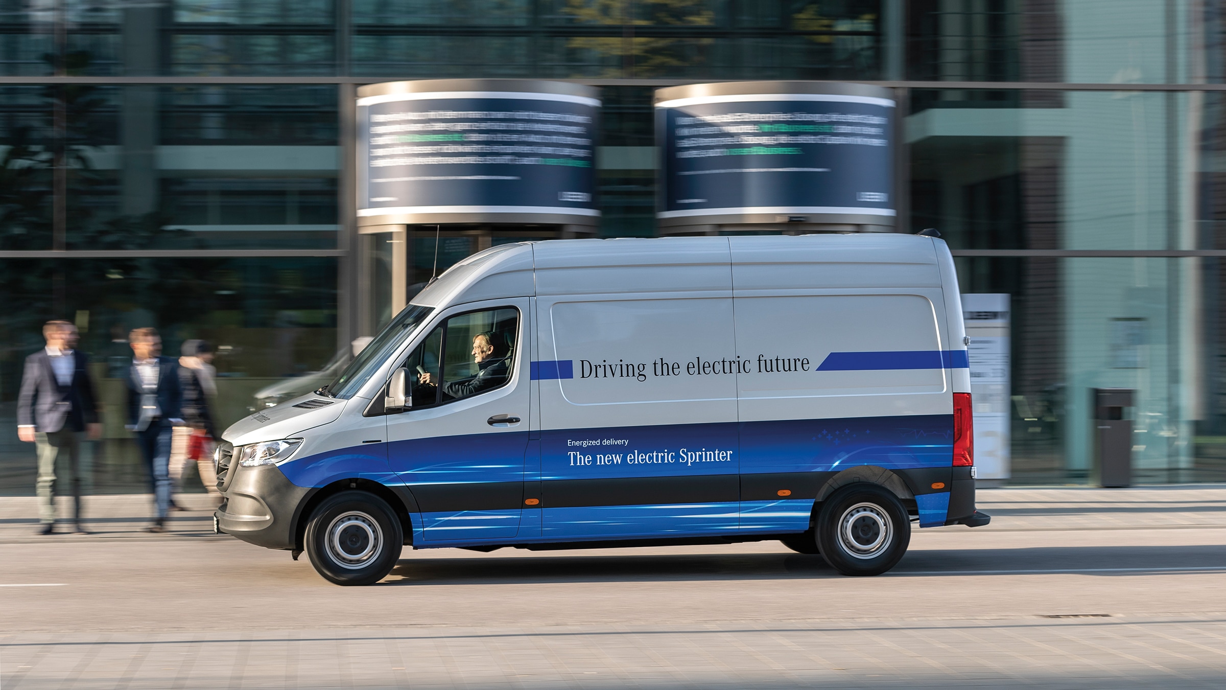 La segunda generación del furgón eSprinter | Historia de los vehículos industriales | Mercedes-Benz Furgoneta de reparto Mercedes-Benz eSprinter Panel Van circulando por una calle de una ciudad moderna