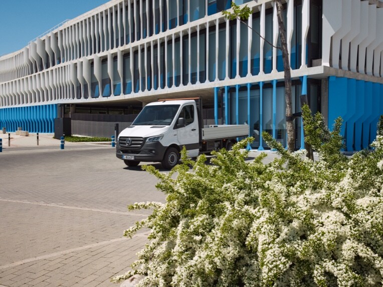 La eSprinter Chasis de Mercedes-Benz como vehículo de plataforma aparcado en frente de un edificio.