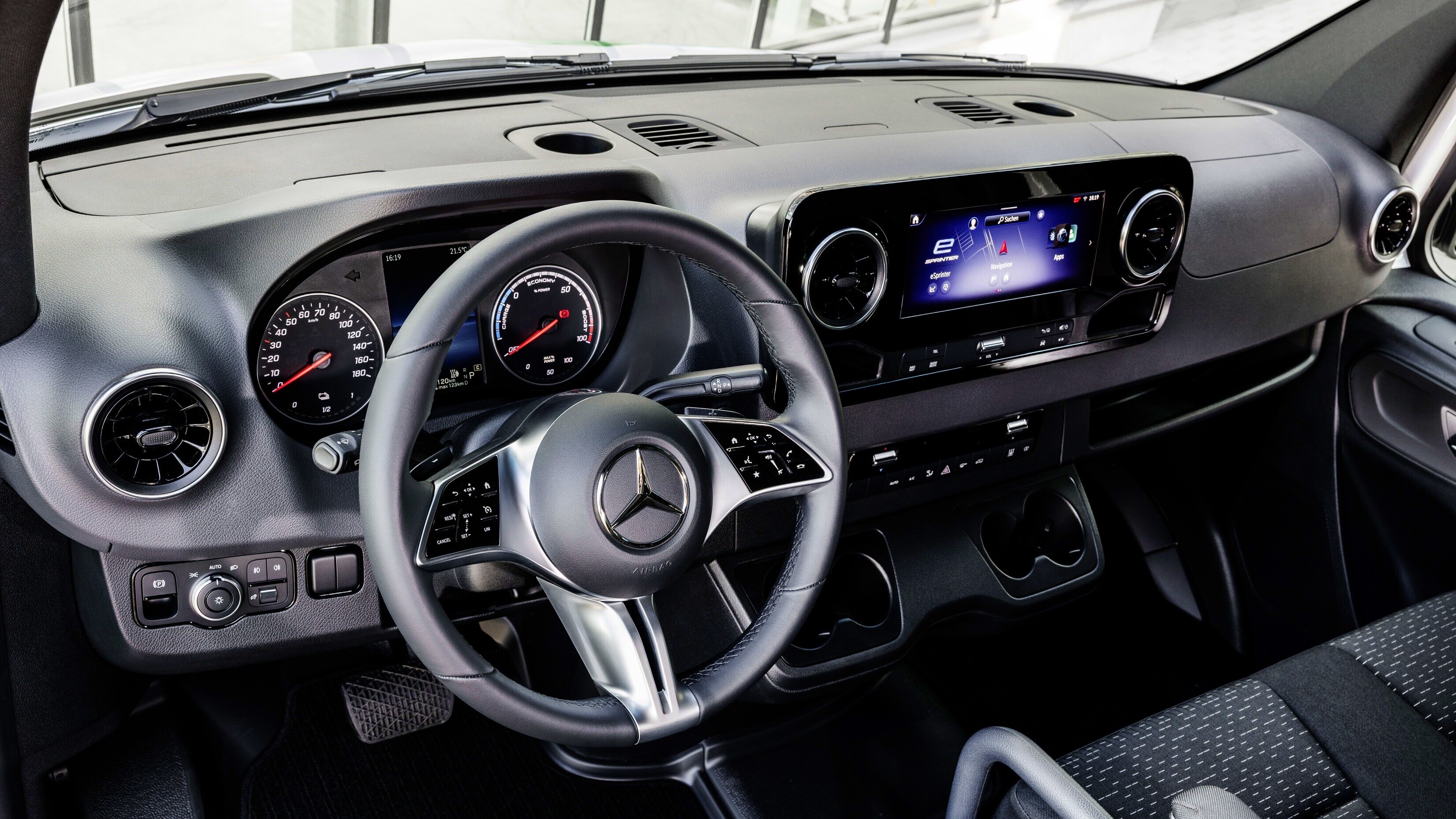 Mercedes-Benz MBUX | Furgonetas y Monovolúmenes Mercedes-Benz Puesto de conducción de la Mercedes-Benz con volante multifunción, cuadro de instrumentos analógico y pantalla multimedia, destacando la conectividad y la ergonomía para el conductor.