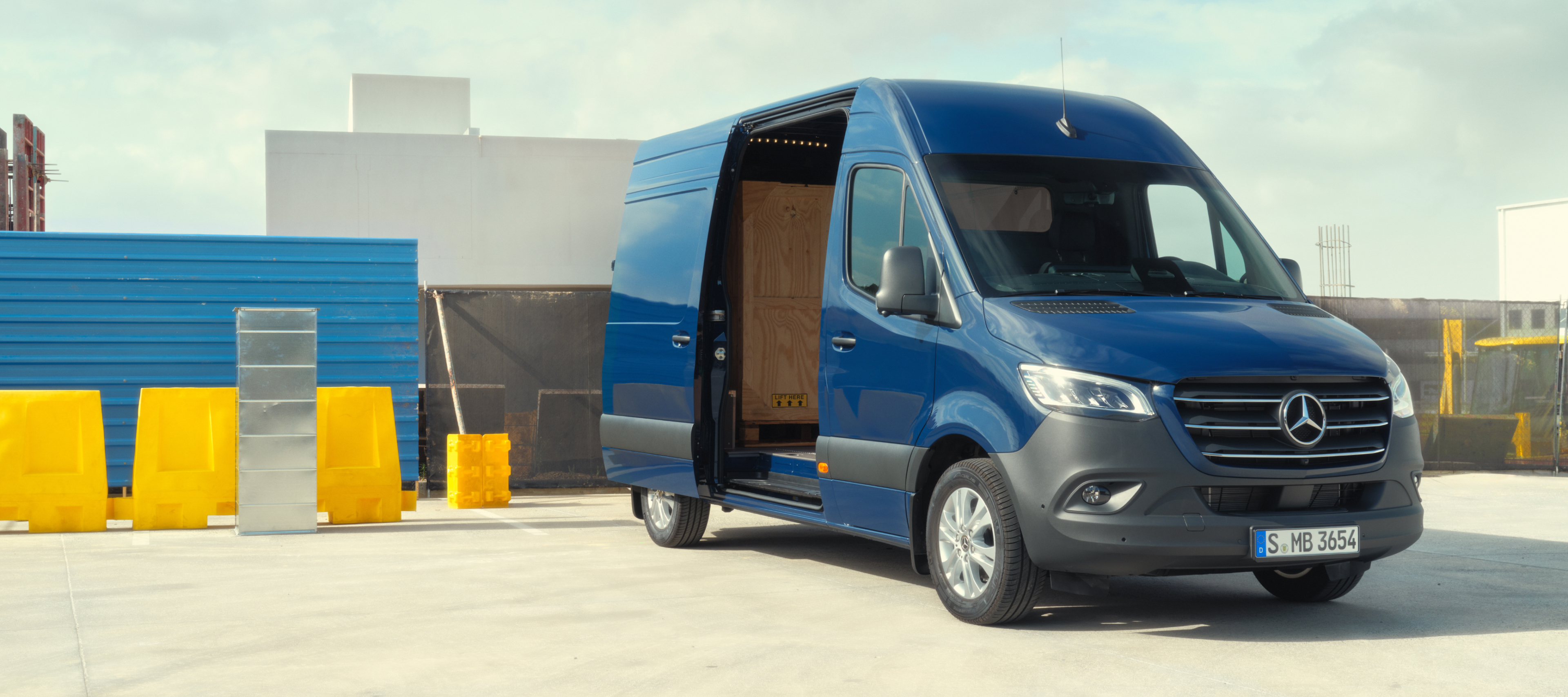 Comparación de vehículos | Sprinter Furgón | Mercedes-Benz Furgón Mercedes-Benz Sprinter delante de materiales de construcción.