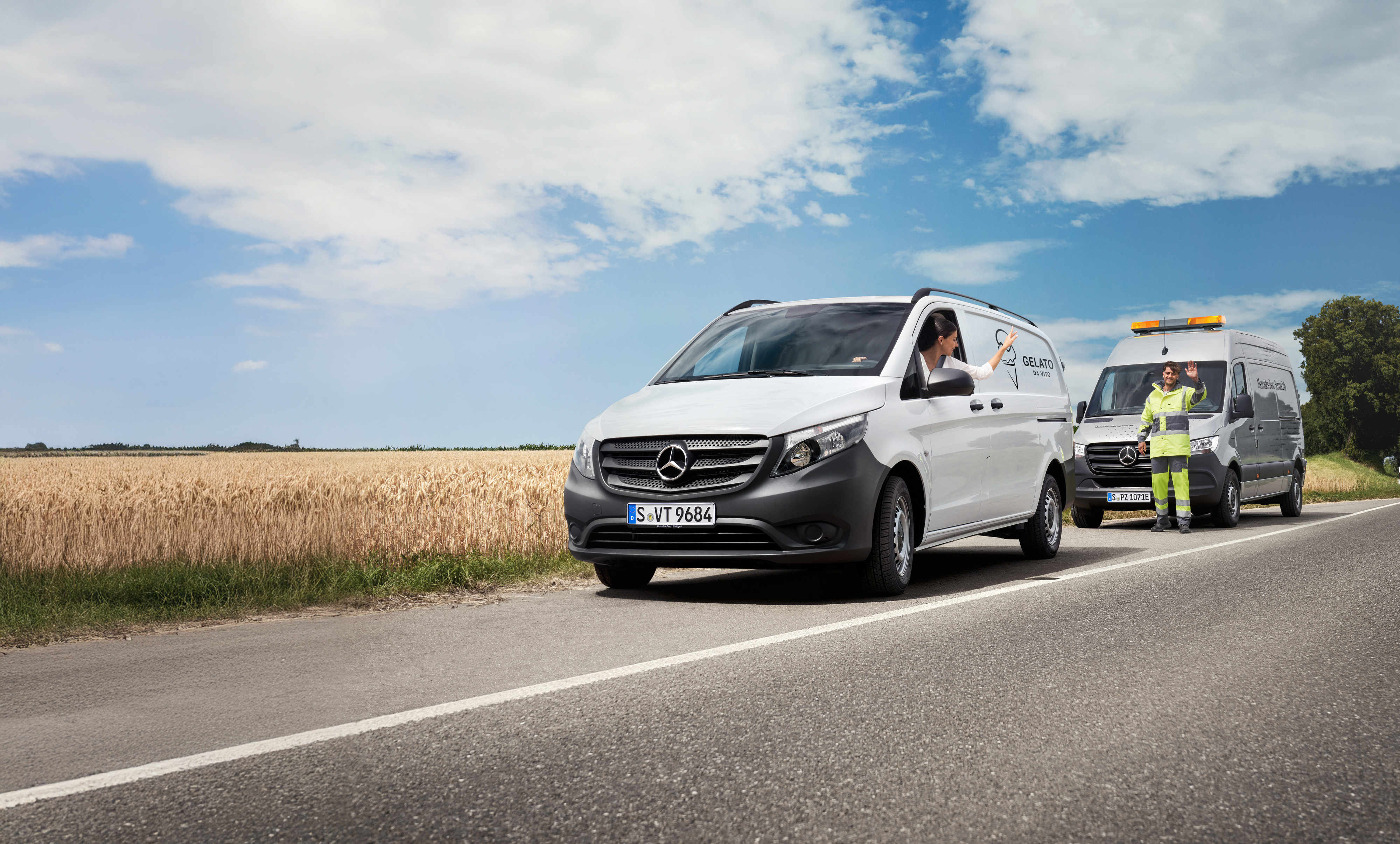 Mercedes Benz | Conveniencia | MobiloVan Una mujer sentada en un Mercedes-Benz Vito blanco saluda a un técnico de servicio de Mercedes-Benz al borde de la carretera.