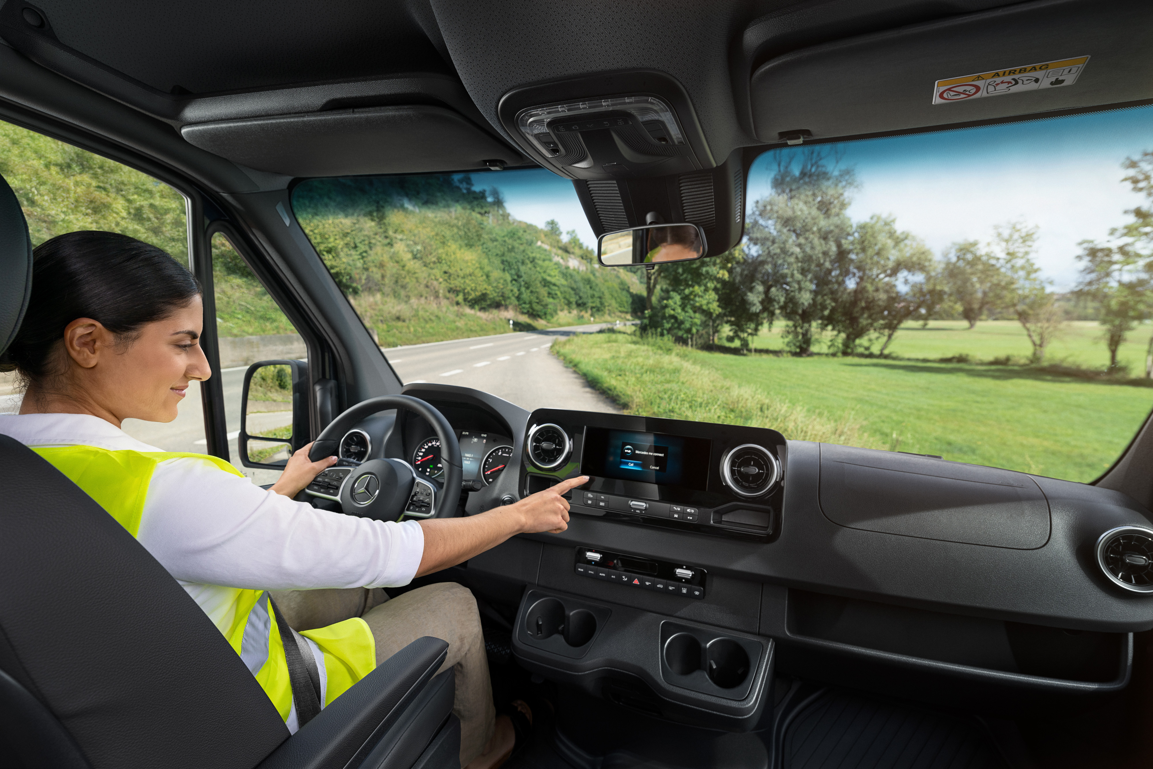 Mercedes Benz | Conveniencia | MobiloVan Una conductora comprueba la pantalla de a bordo de tu furgón Mercedes-Benz.