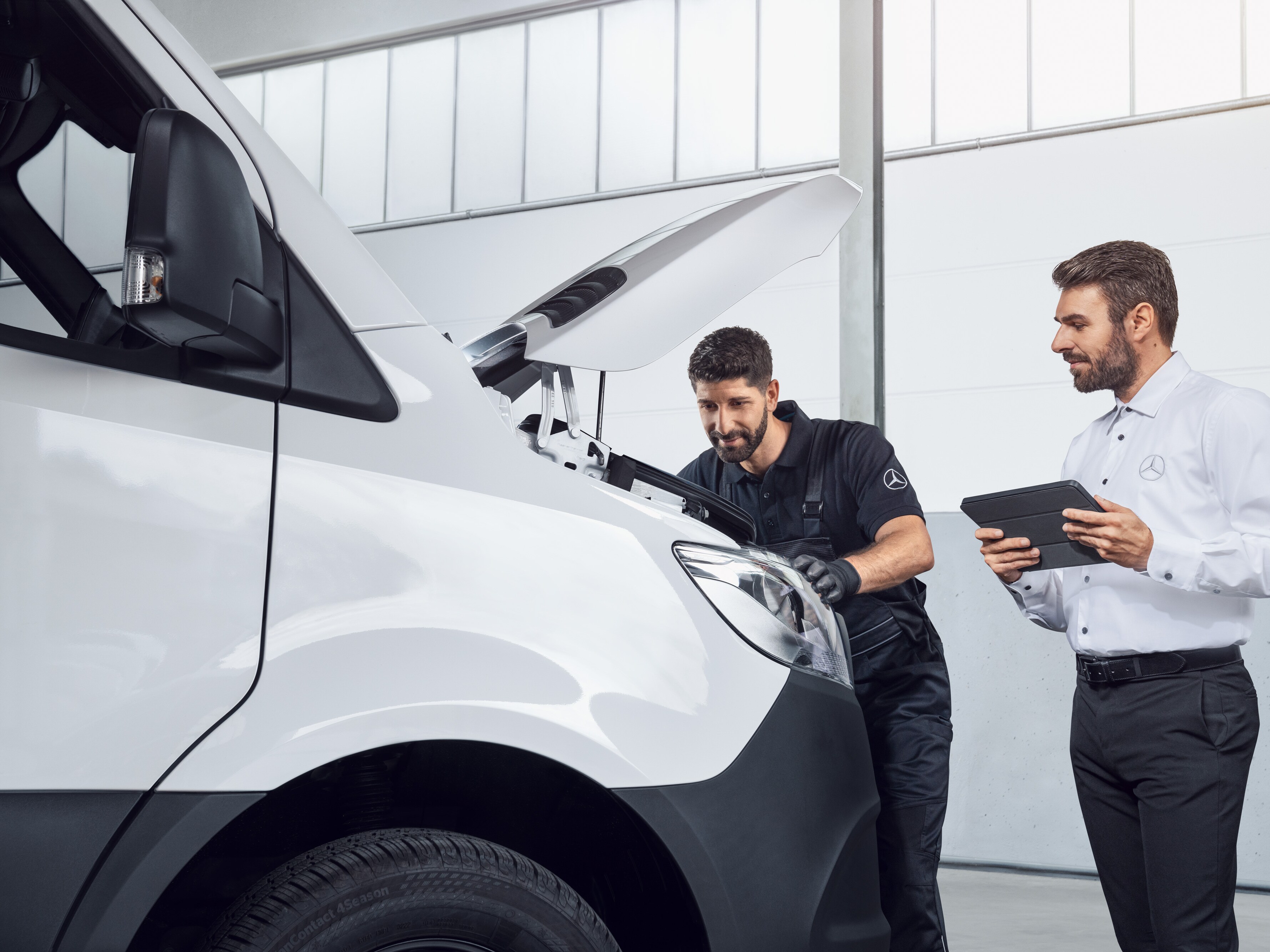 Dos hombres testeando un Mercedes Sprinter con tablet y capó abierto, tema: repuestos de Sprinter Mercedes-Benz.
