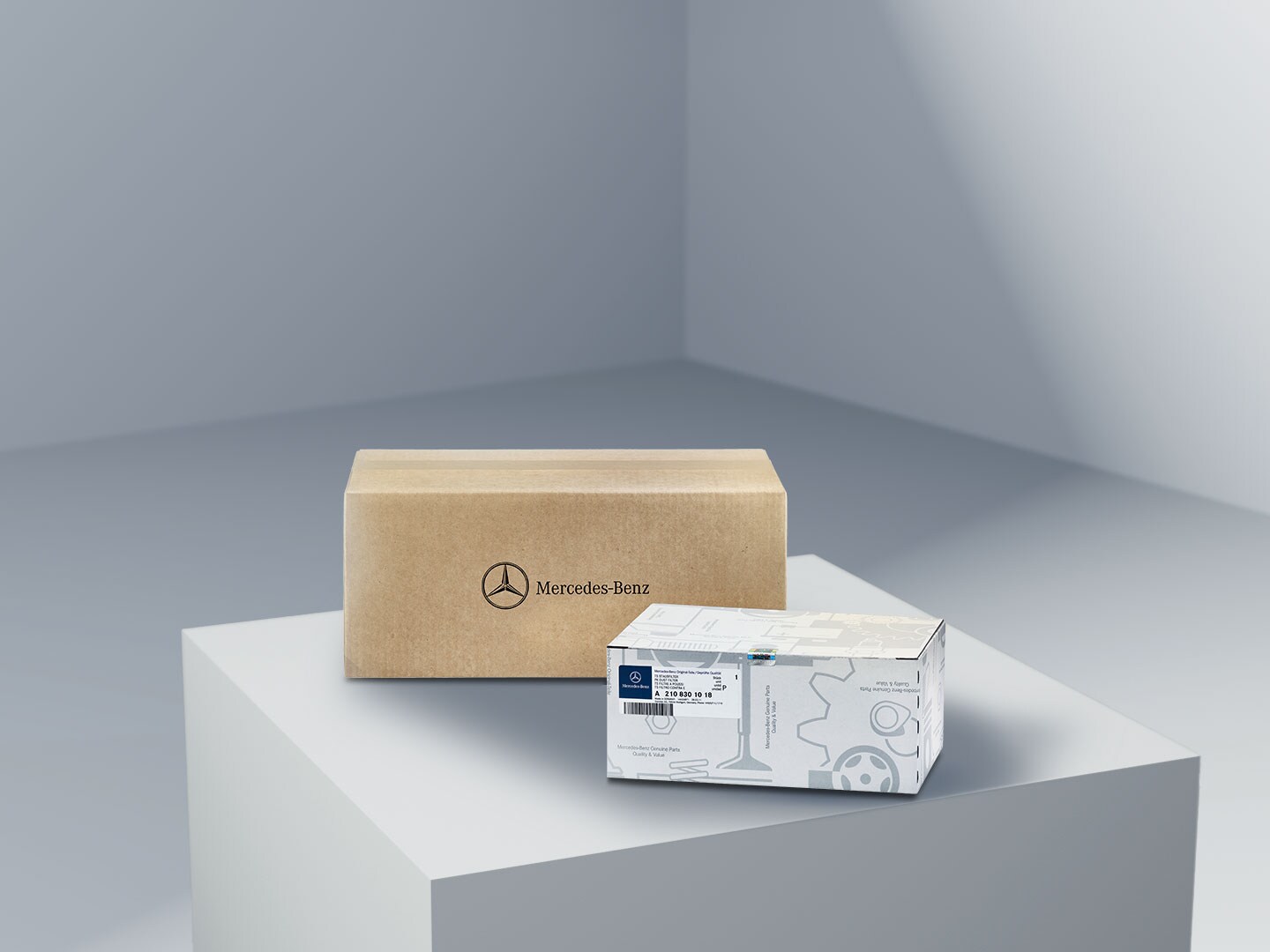 Dos paquetes con el logotipo de Mercedes-Benz, símbolo de los recambios originales de Mercedes-Benz, sobre una plataforma de color claro.