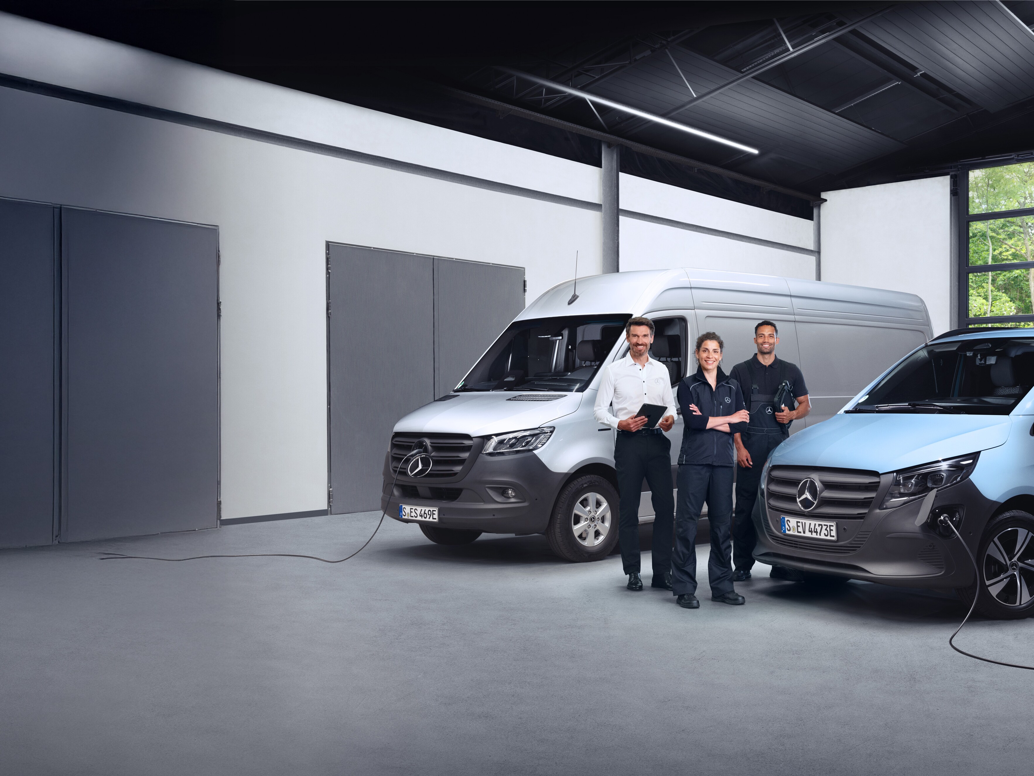 Tres empleados delante de furgonetas Mercedes-Benz, simbolizando calidad.
