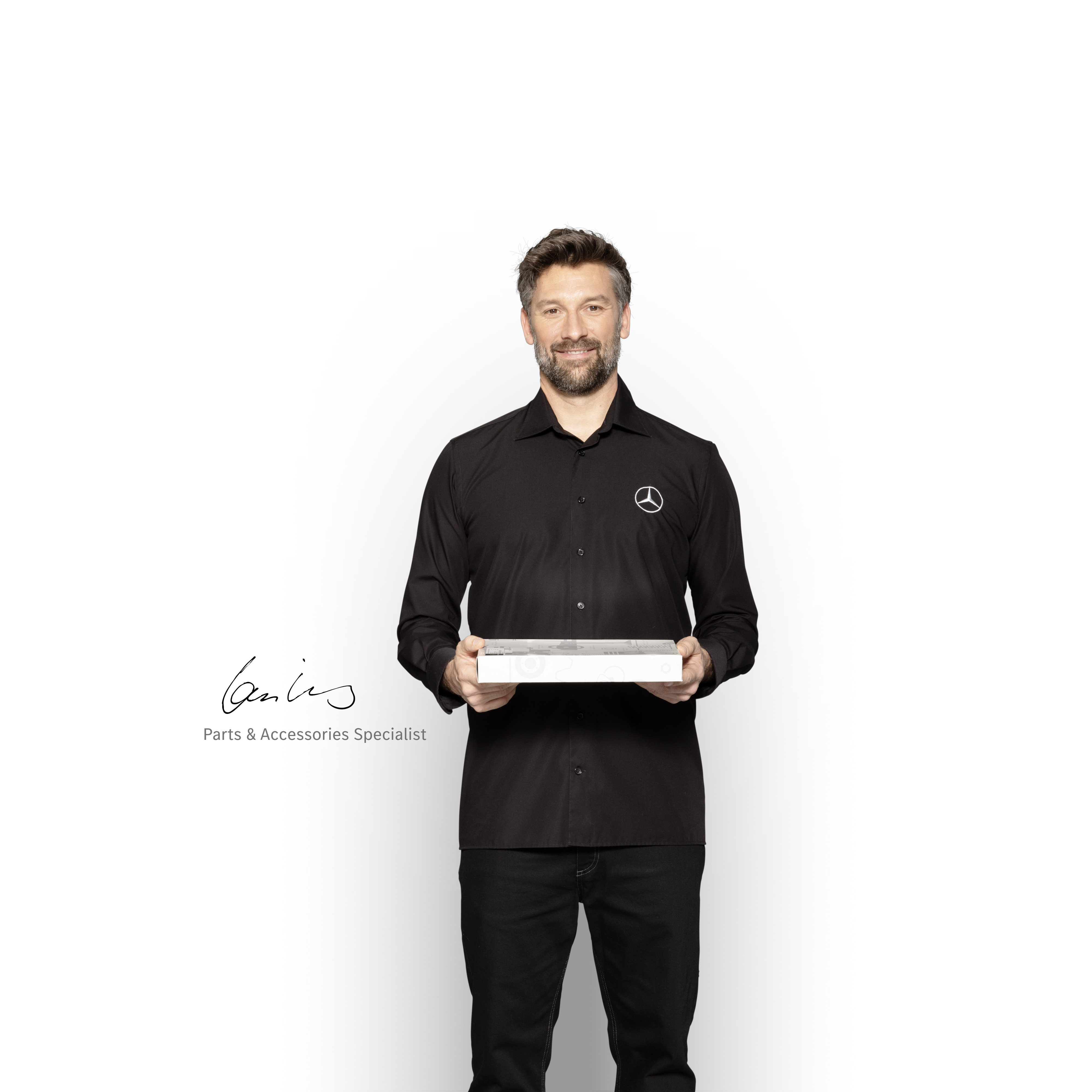 Mercedes-Benz | Recambios originales de calidad para furgones Técnico interno de Mercedes-Benz con una caja en las manos para mostrar recambios originales Mercedes-Benz.