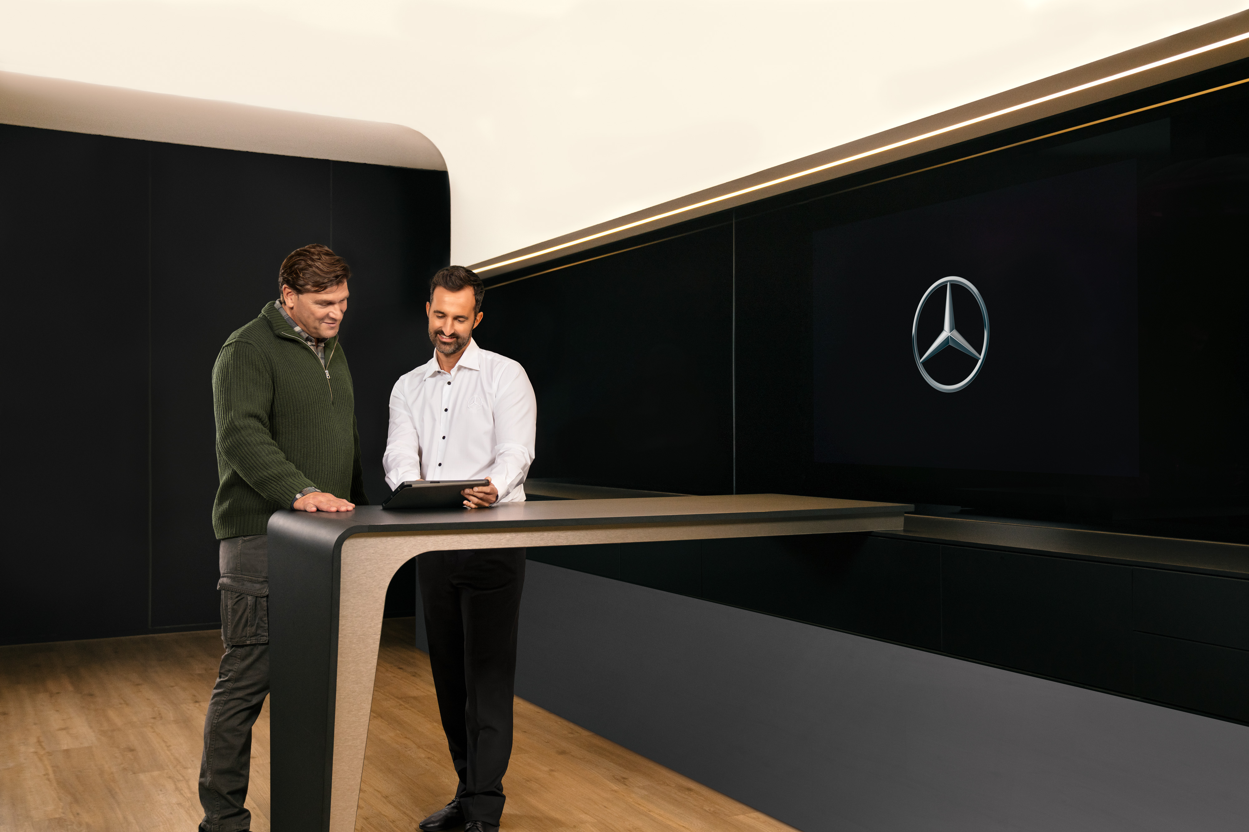 Mercedes-Benz | Servicios - vista general | ServiceCare Dos hombres con una tablet, conversando sobre el servicio para vehículos industriales de Mercedes-Benz .