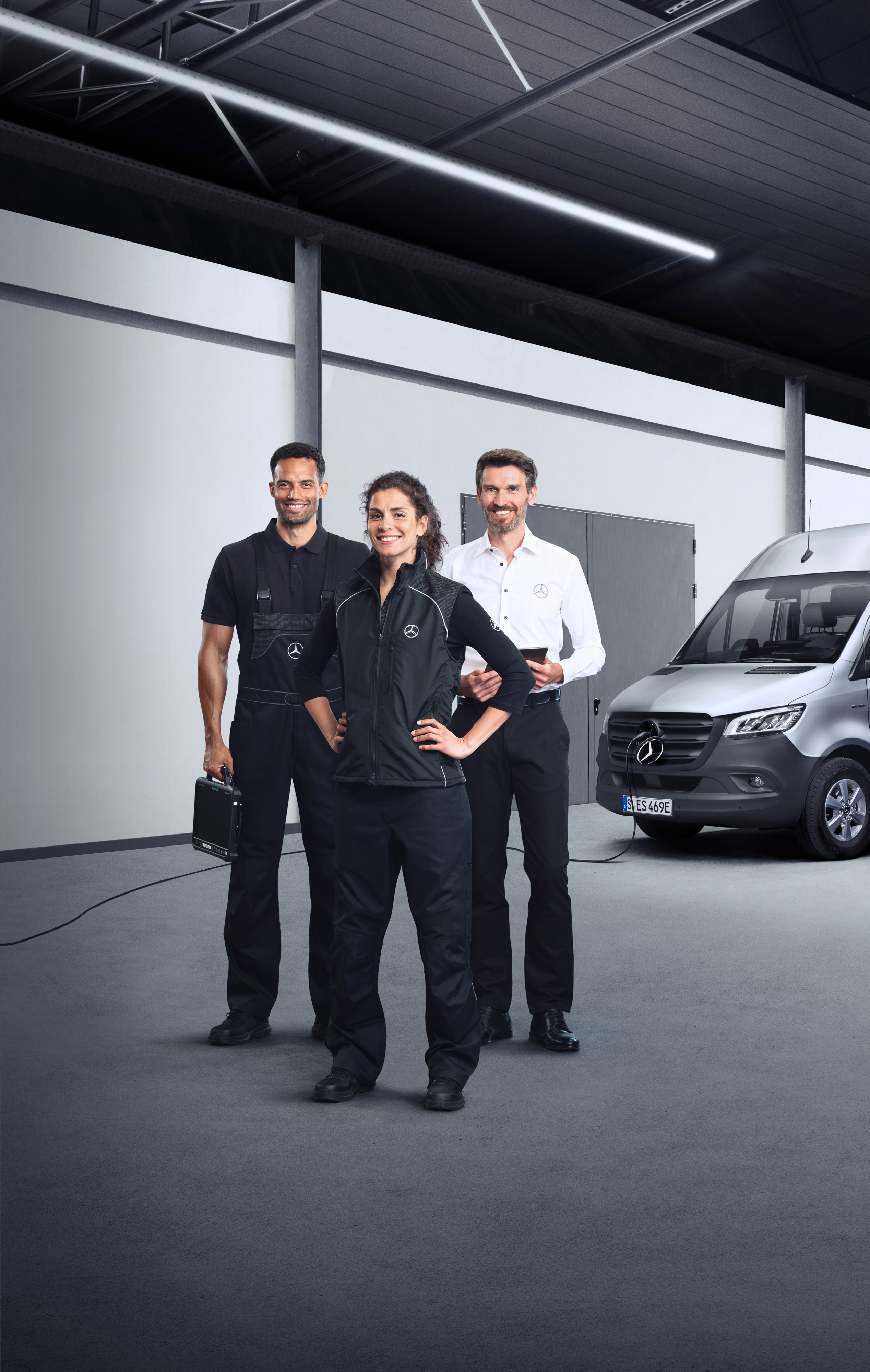 Mercedes-Benz | Servicios - vista general | Servicios para furgones eléctricos Tres empleados delante de un Mercedes-Benz eSprinter plateado con el cable de carga conectado.