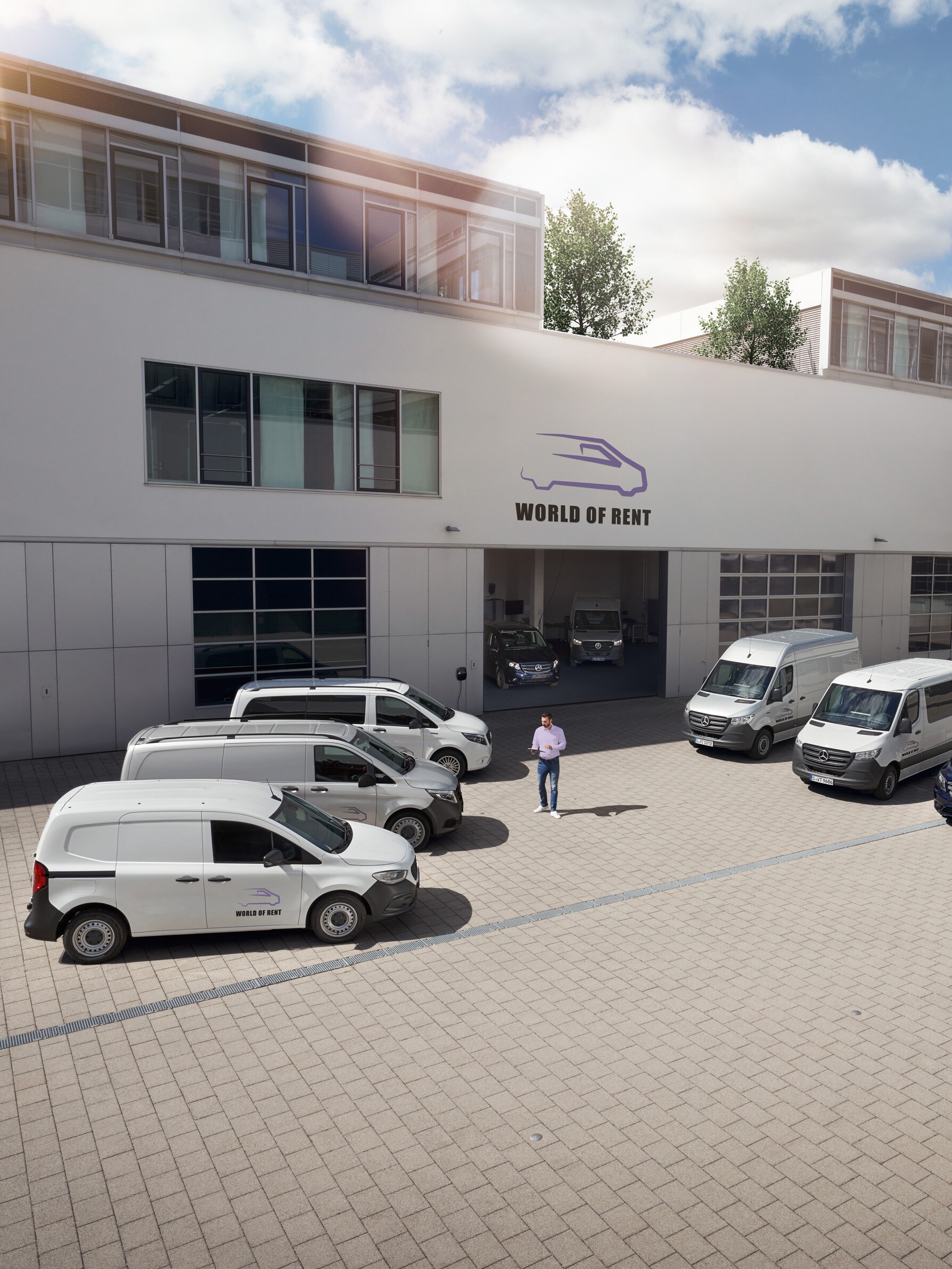 Una flota de furgones Mercedes-Benz delante del edificio de una empresa.