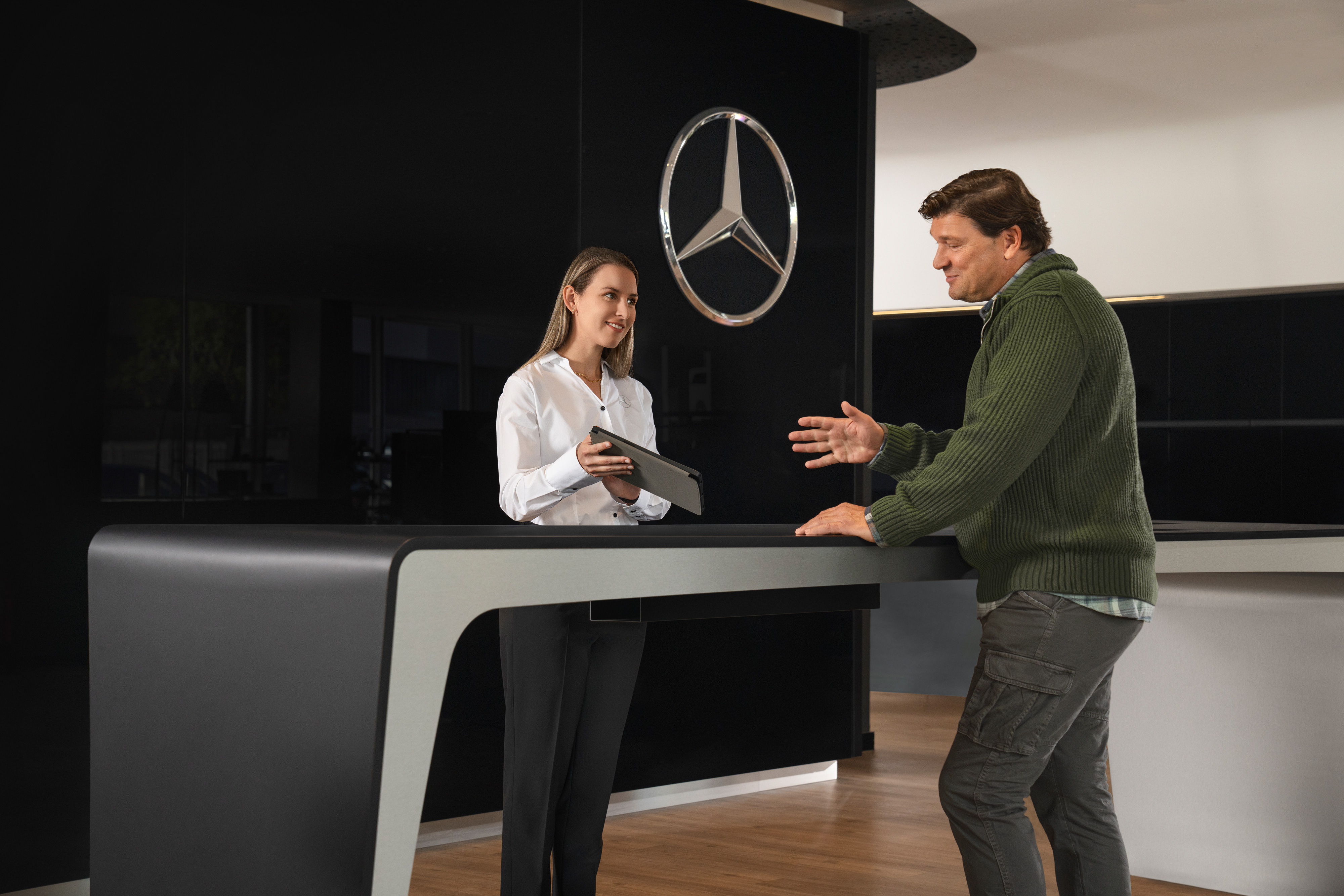 Mercedes-Benz | Servicio para vehículos eléctricos | Consultas Un asesor de Mercedes-Benz dando información personalizada a unos clientes .