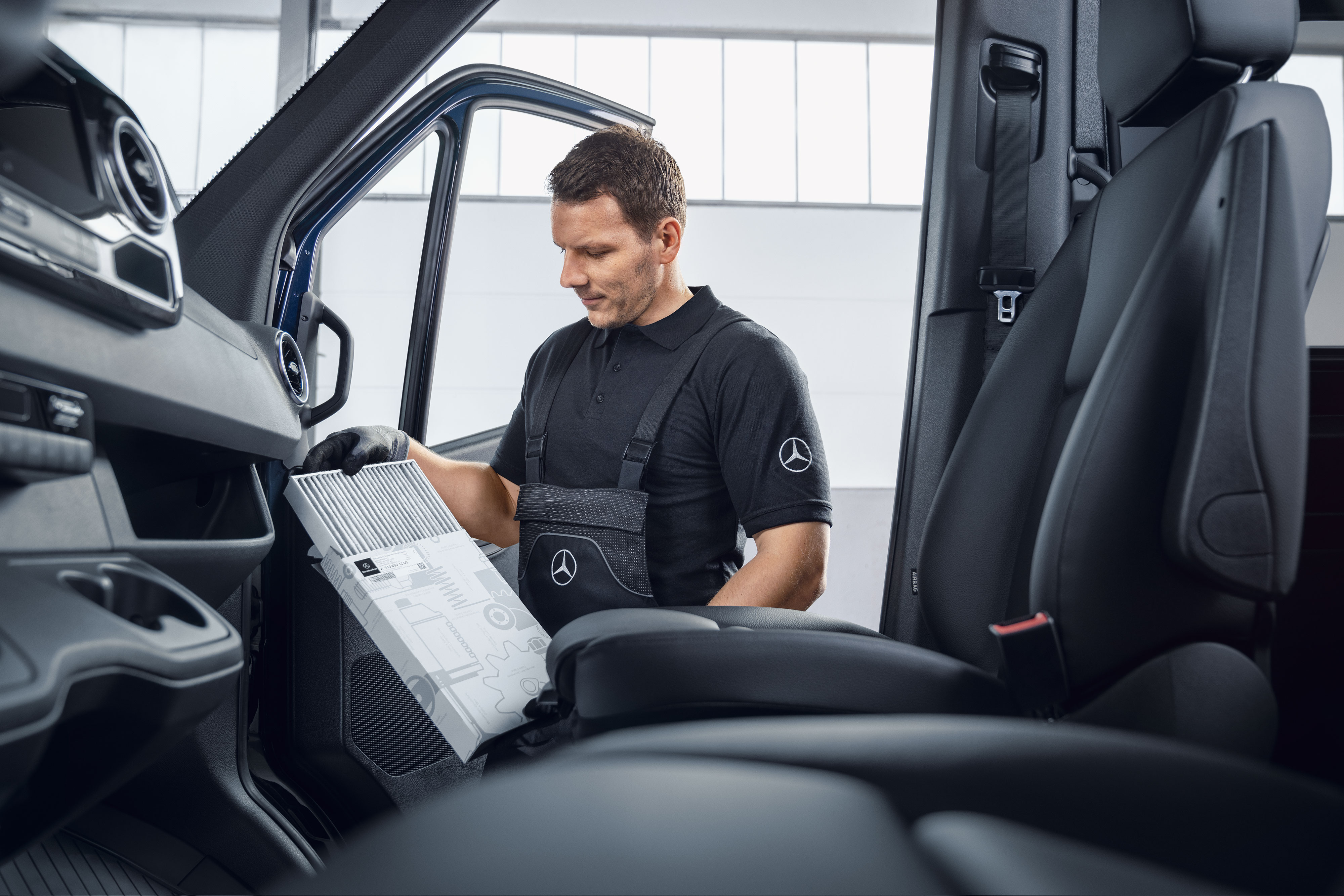 Mercedes-Benz | Mantenimiento | Mantenimiento periódico Un mecánico de Mercedes-Benz cambiando los filtros de aire.