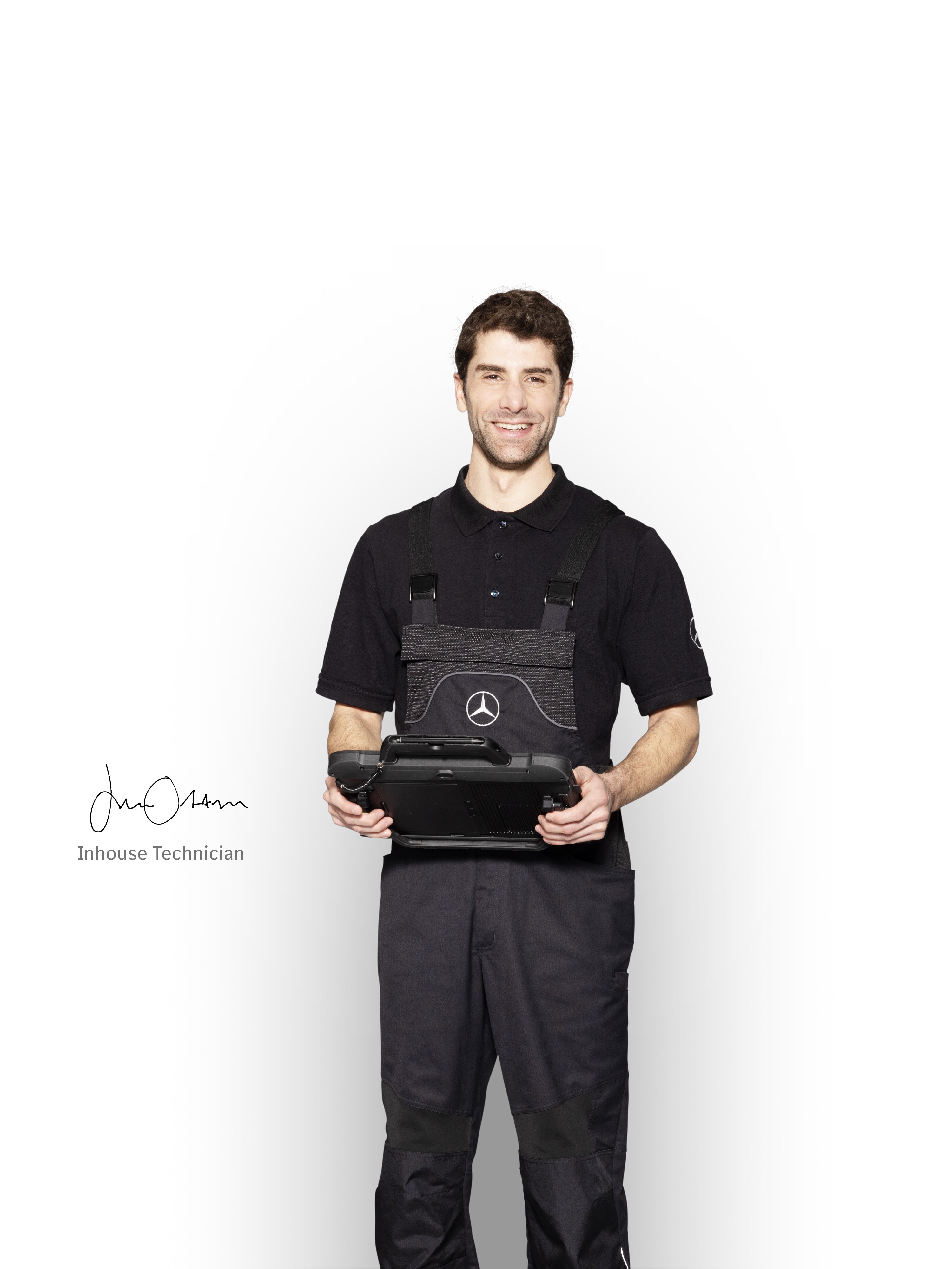 Mecánico de Mercedes-Benz en ropa de trabajo sosteniendo una tablet lista para el informe de daños.