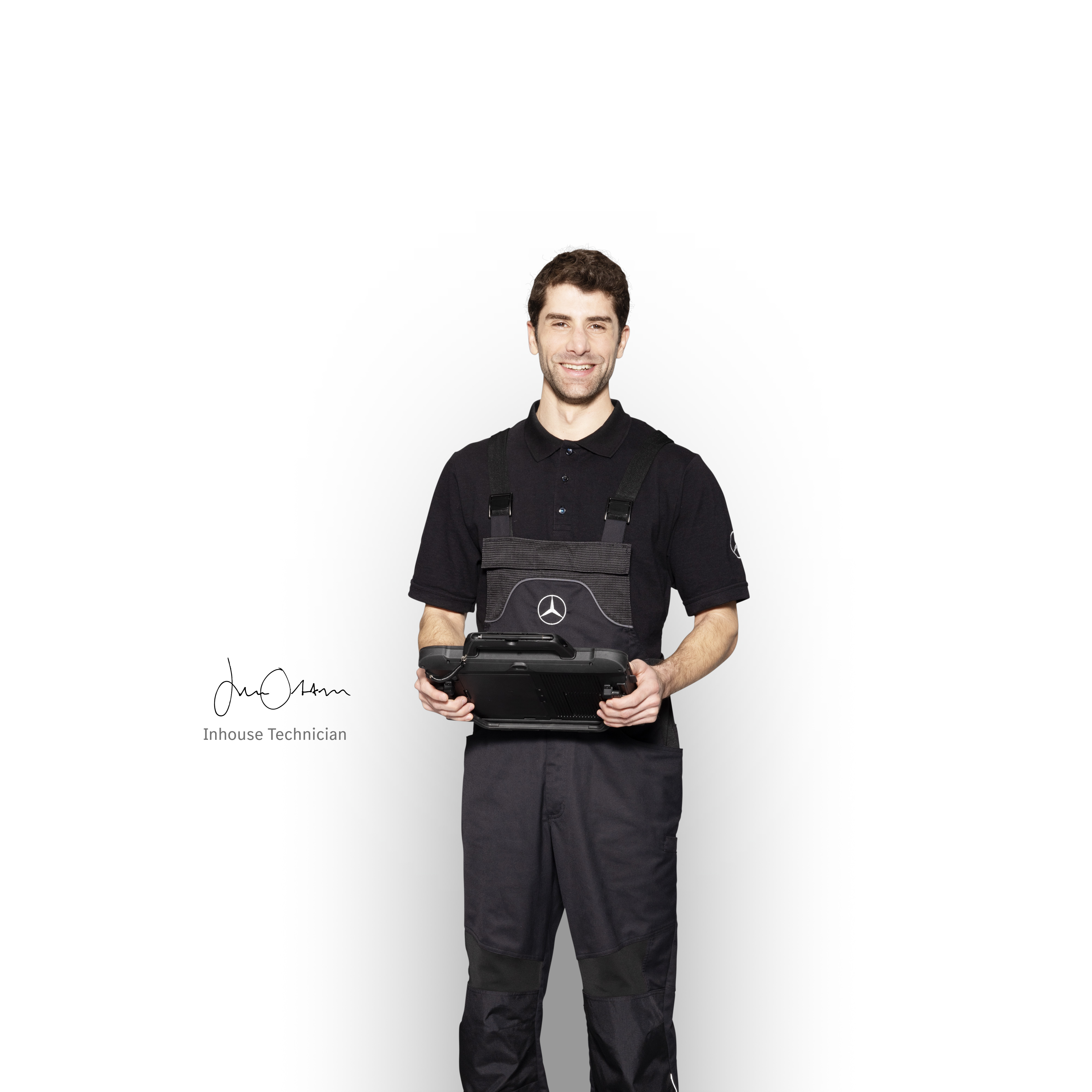 Mercedes-Benz | Reparación Mecánico de Mercedes-Benz en ropa de trabajo sosteniendo una tablet lista para el informe de daños.