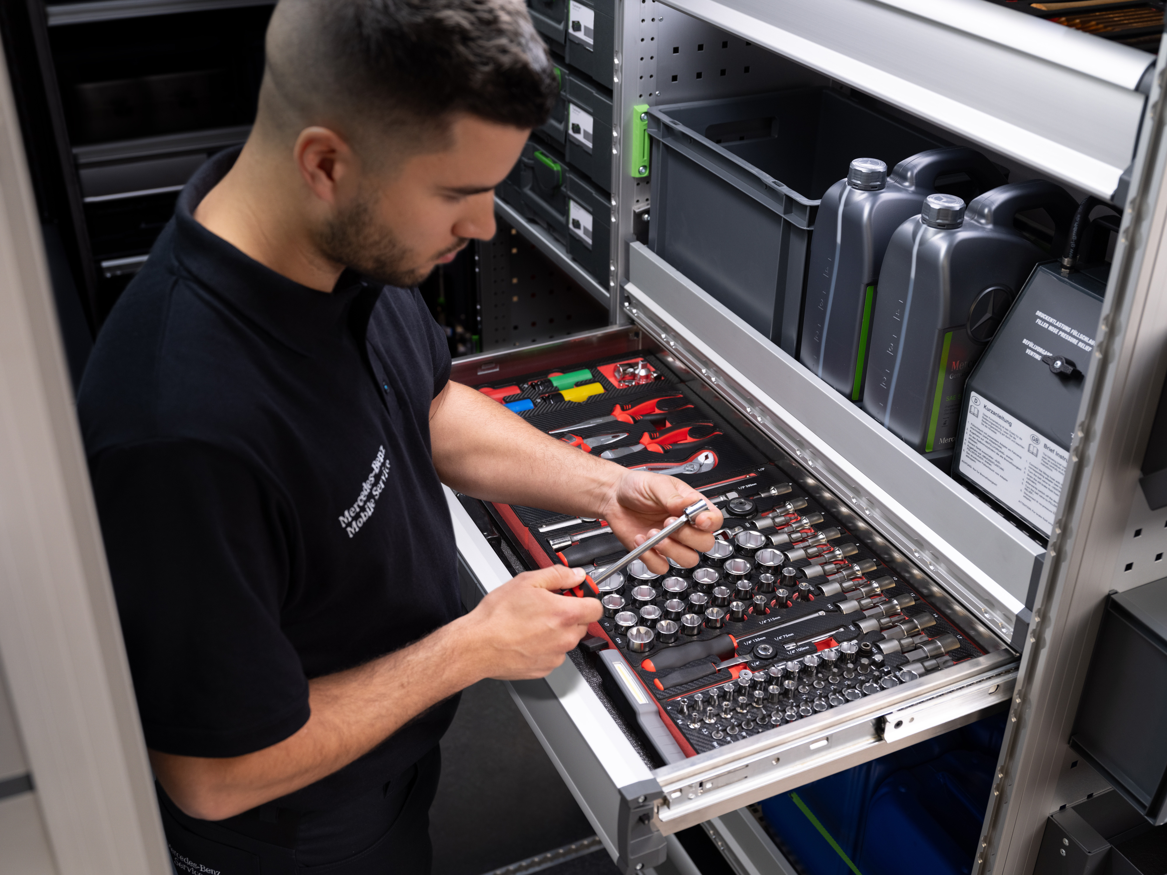 Mercedes-Benz | Servicio móvil | Electrónica Un técnico eligiendo un artículo de un cajón lleno de herramientas.