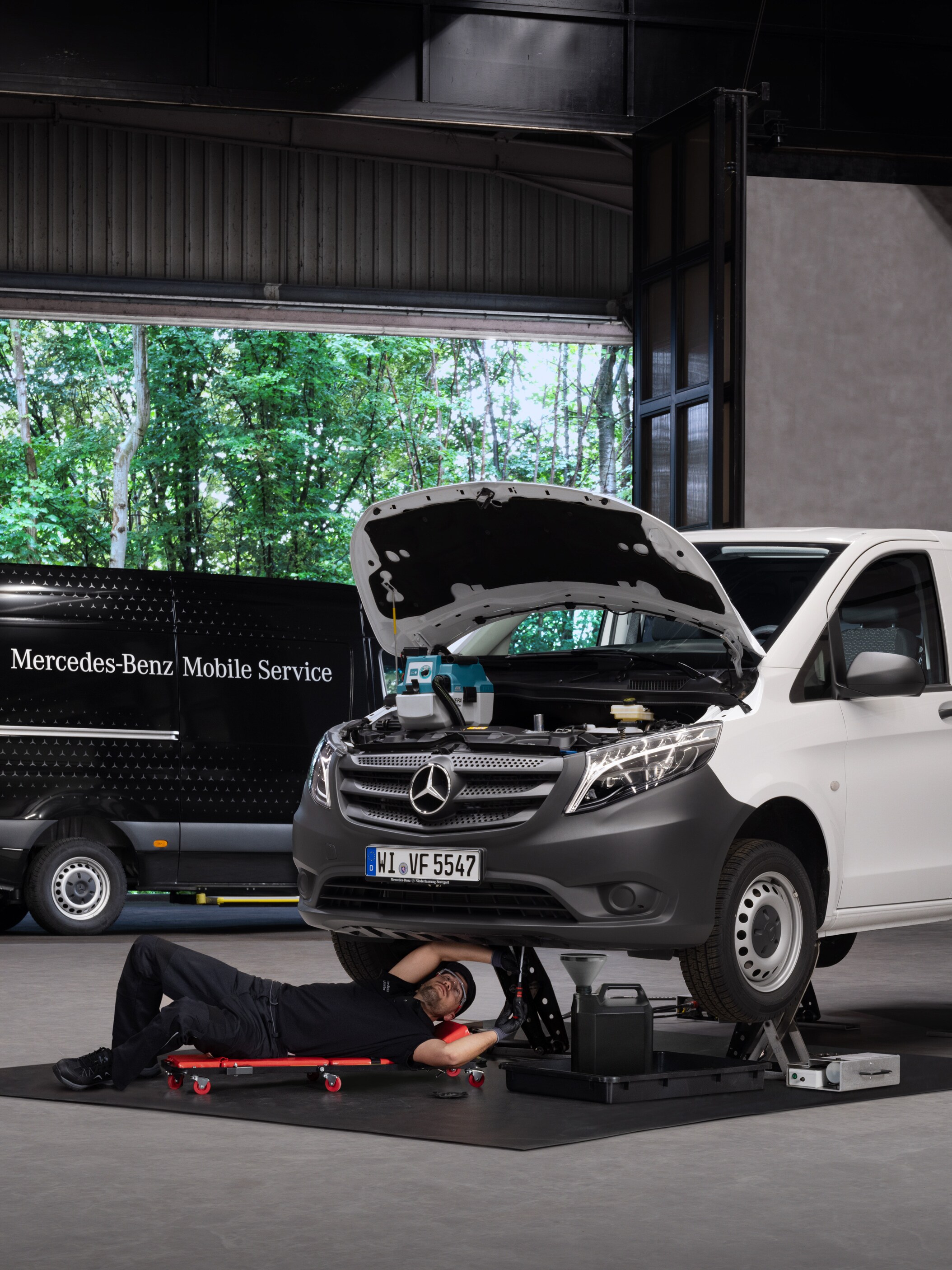 Un técnico reparando un furgón Mercedes-Benz Vito blanco.