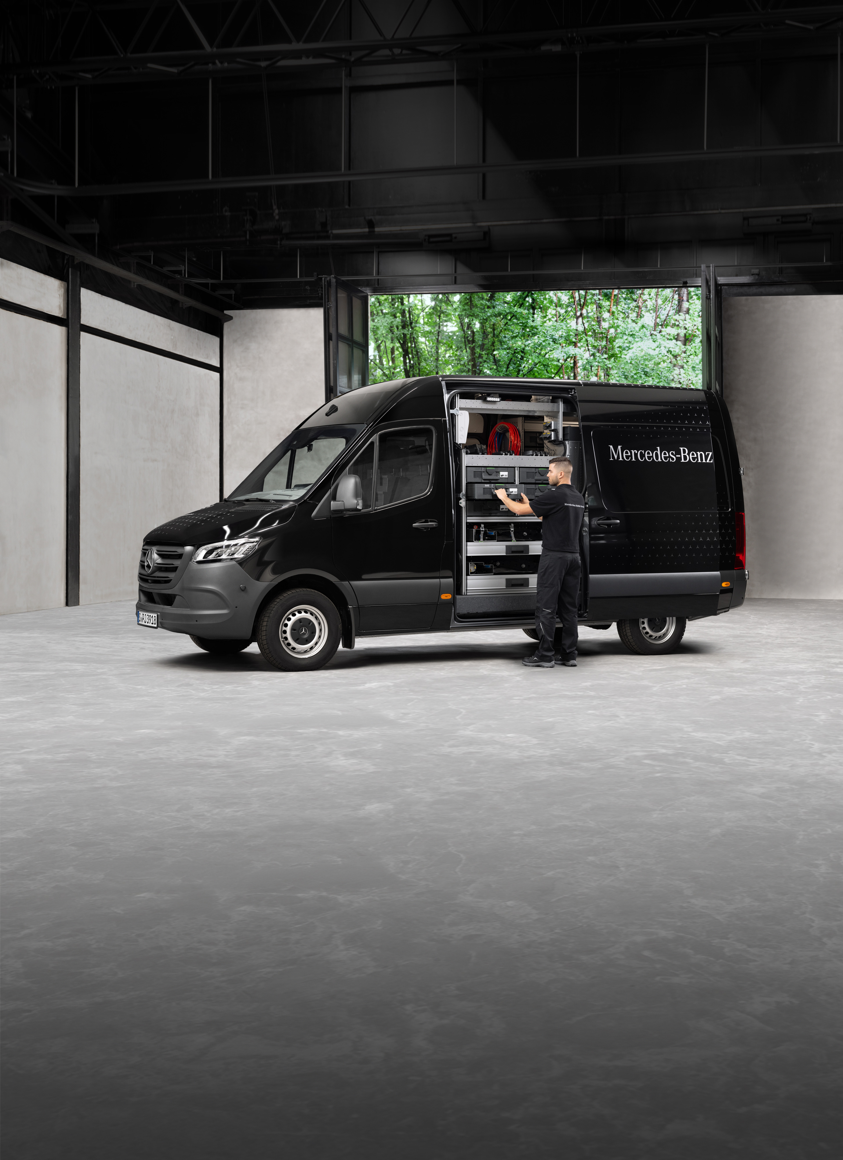 Mercedes-Benz | Servicio móvil | Revisión estacional Un técnico retirando herramientas de un furgón Mercedes-Benz Sprinter negro.