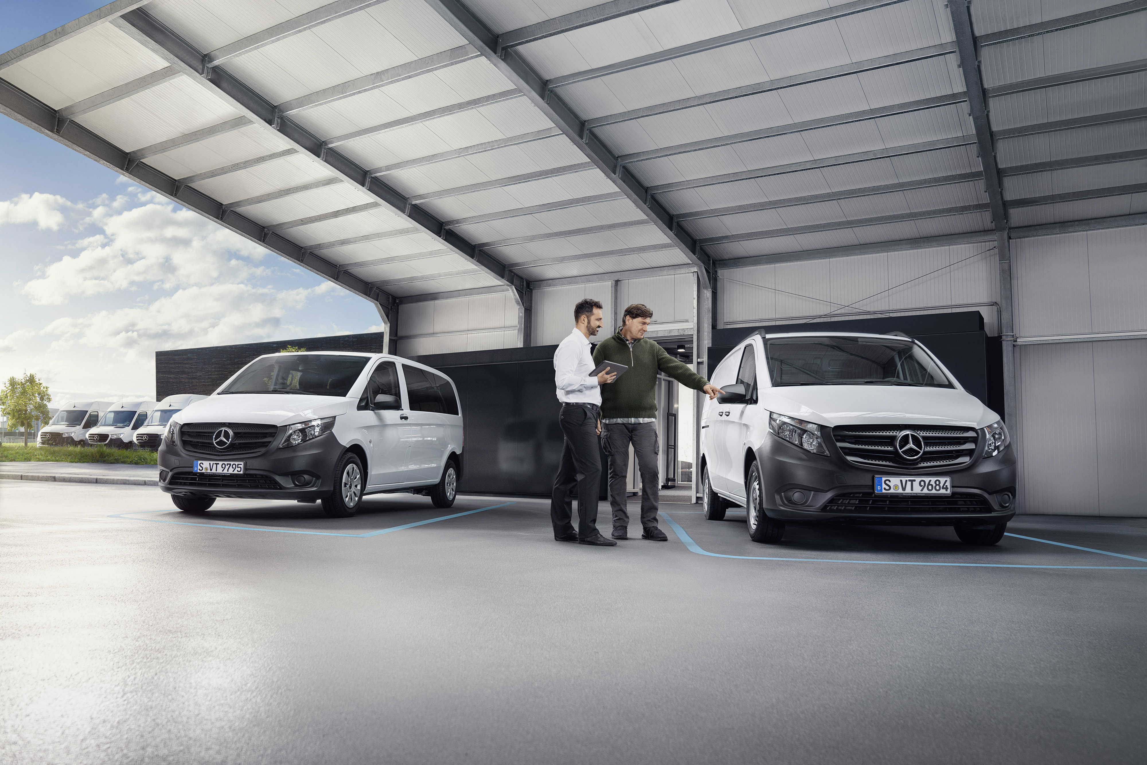 Mercedes-Benz | Llamadas al taller Agente de atención al cliente de Mercedes-Benz con un cliente en un punto de servicio asociado delante de un furgón.