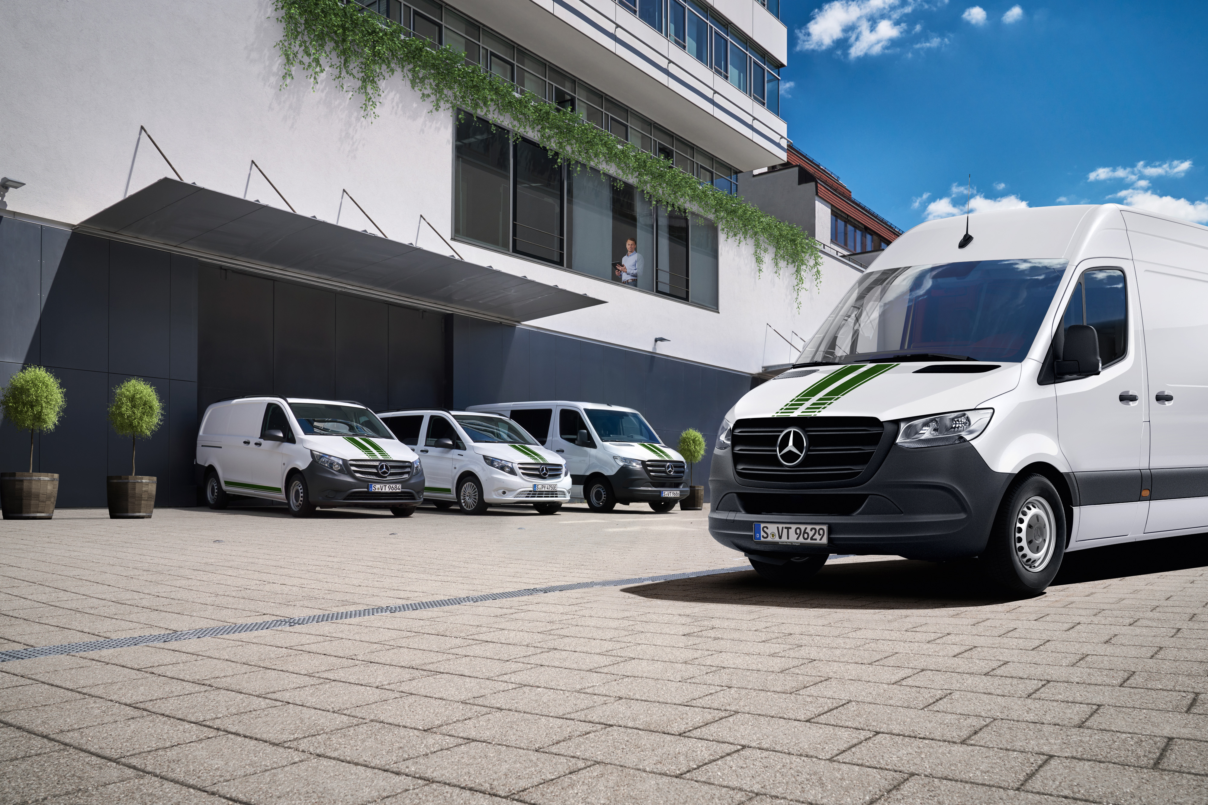 Mercedes-Benz | Tecnología para furgones | Van Uptime Monitor Una flota de furgones Mercedes-Benz delante de un edificio, símbolo del control digital de flotas.