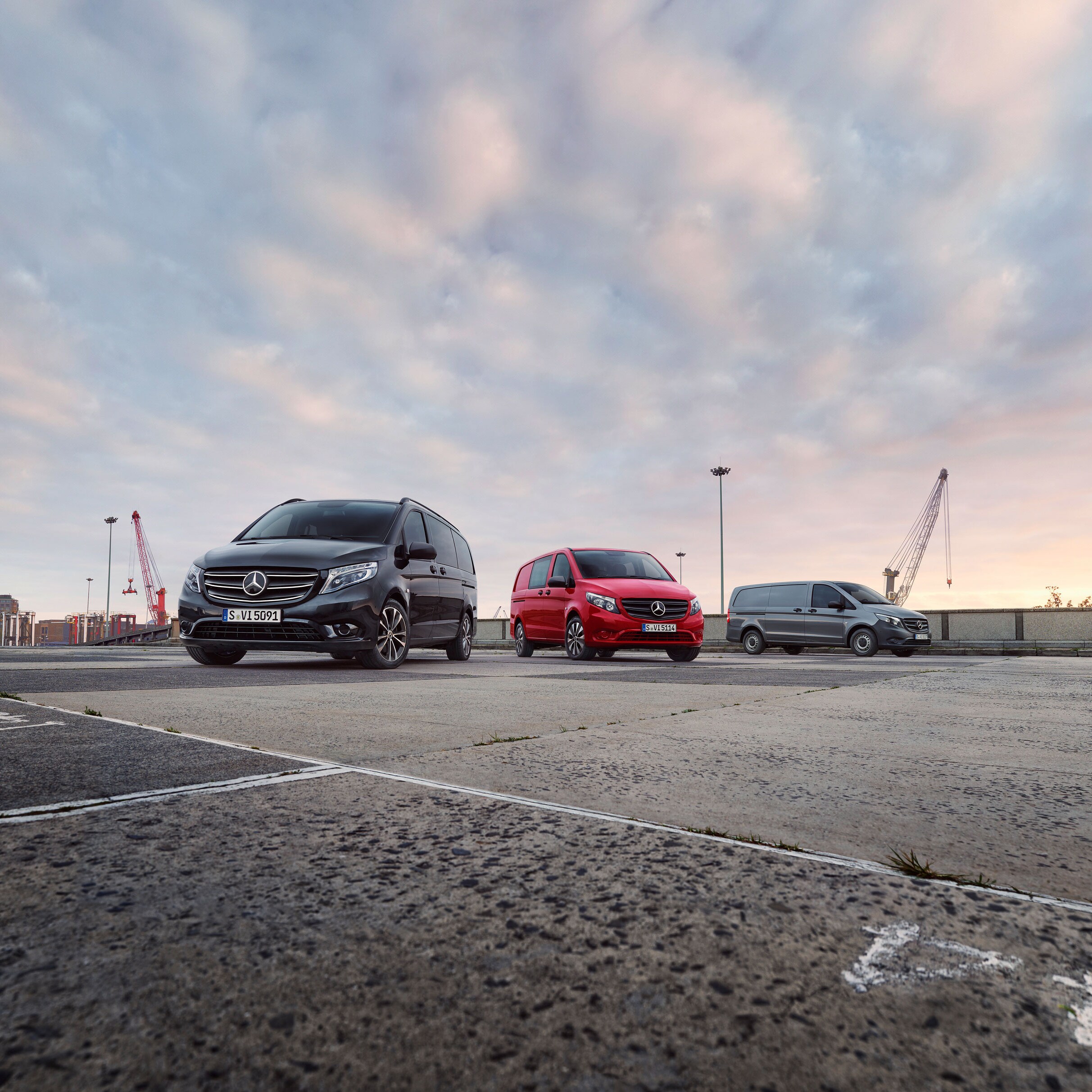 Gama de furgonetas Mercedes-Benz estacionadas en un puerto al atardecer, destacando la versatilidad de los modelos para diferentes necesidades de transporte profesional.