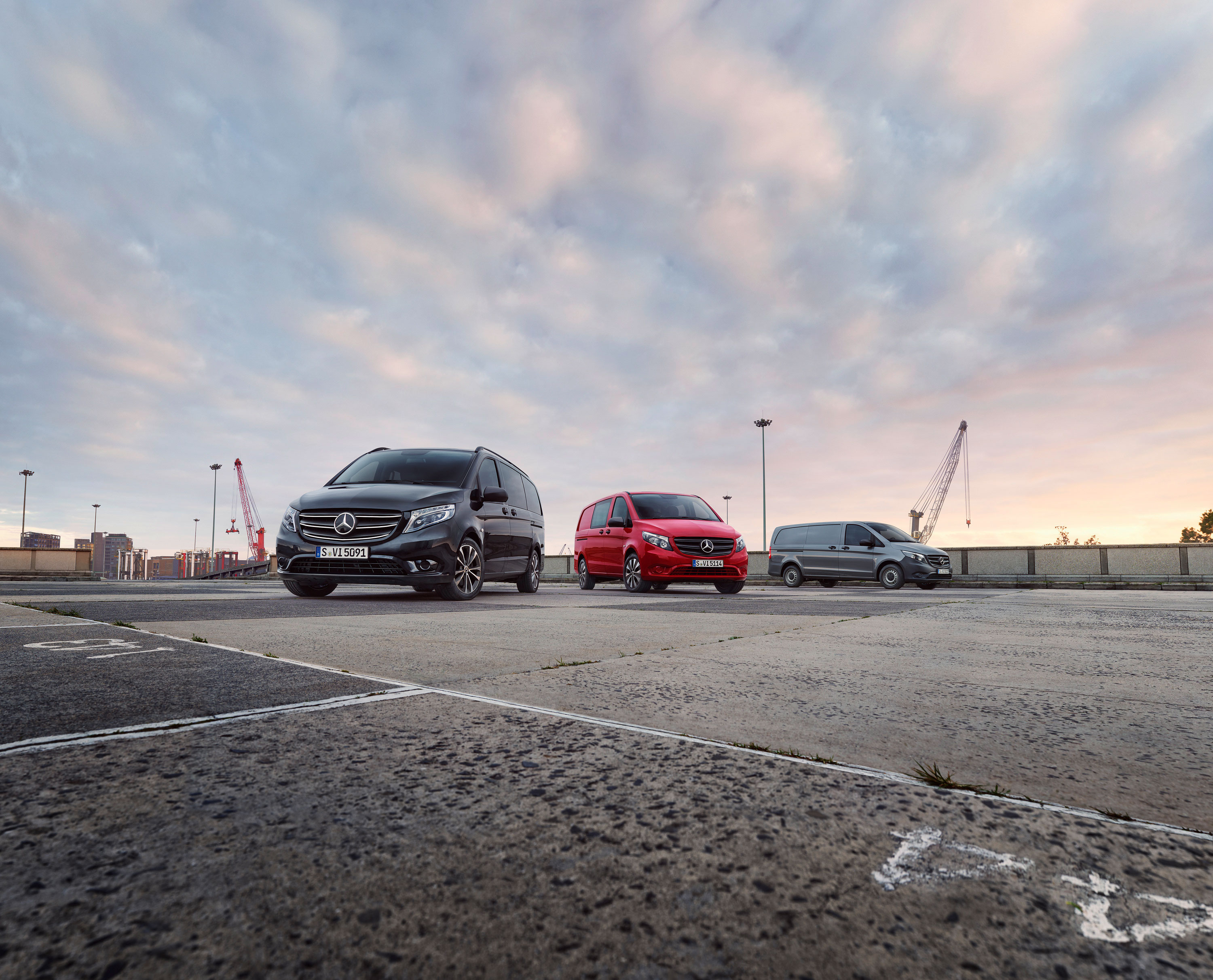 Todos los nuevos modelos de Vito | Dimensiones & Características | Mercedes-Benz Gama de furgonetas Mercedes-Benz estacionadas en un puerto al atardecer, destacando la versatilidad de los modelos para diferentes necesidades de transporte profesional.