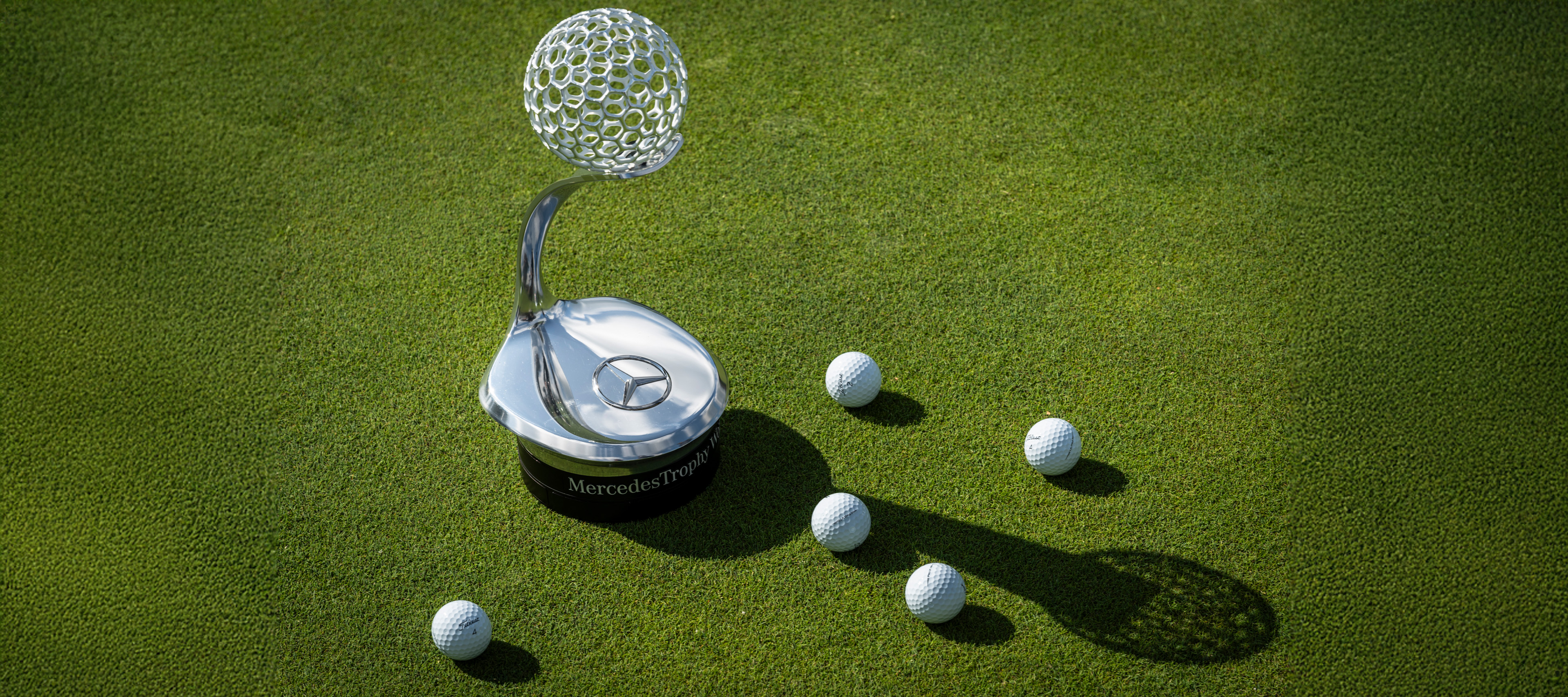 MercedesTrophy | Mercedes-Benz Imagen del trofeo del MercedesTrophy con pelotas de golf alrededor