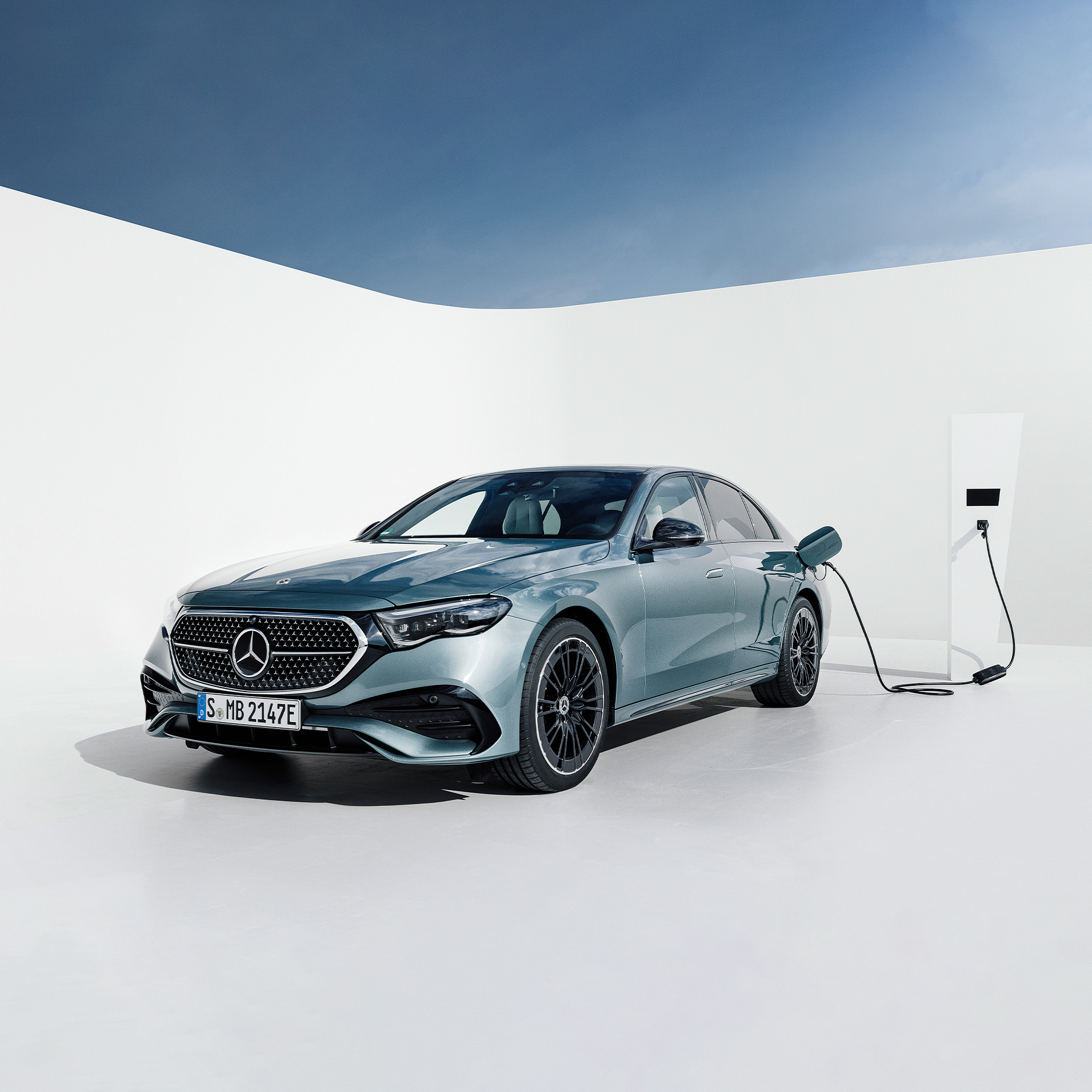 Clase E Berlina Hibrido Enchufable | Mercedes-Benz Visual de un Clase E Berlina Hibrido Enchufable gris en una estación de carga