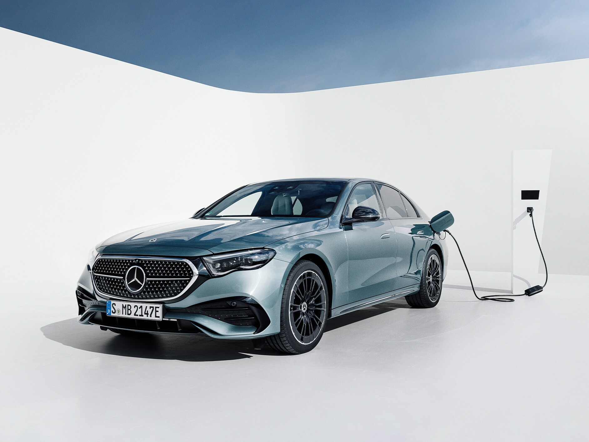 Visual de un Clase E Berlina Hibrido Enchufable gris en una estación de carga