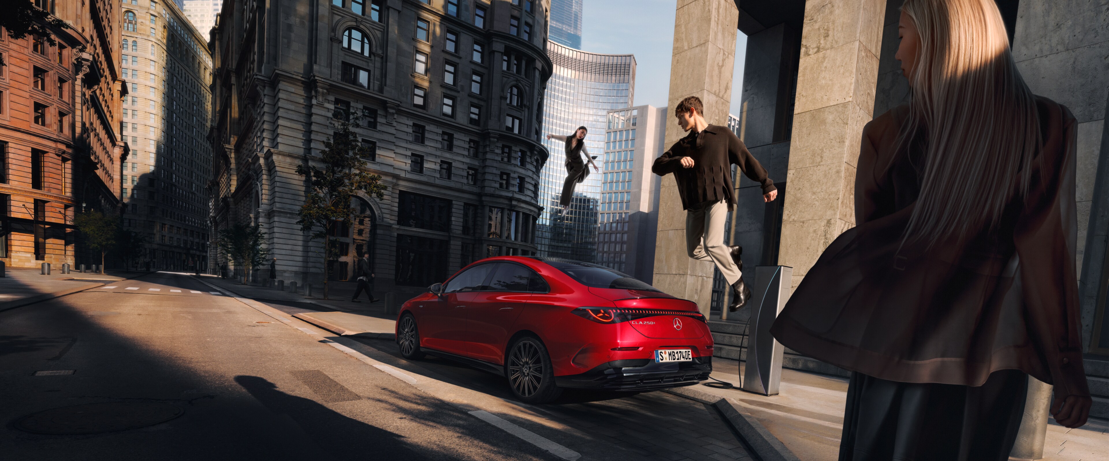 Dos personas volando sobre un CLA Eléctrico de Mercedes-Benz y una mujer de espaldas