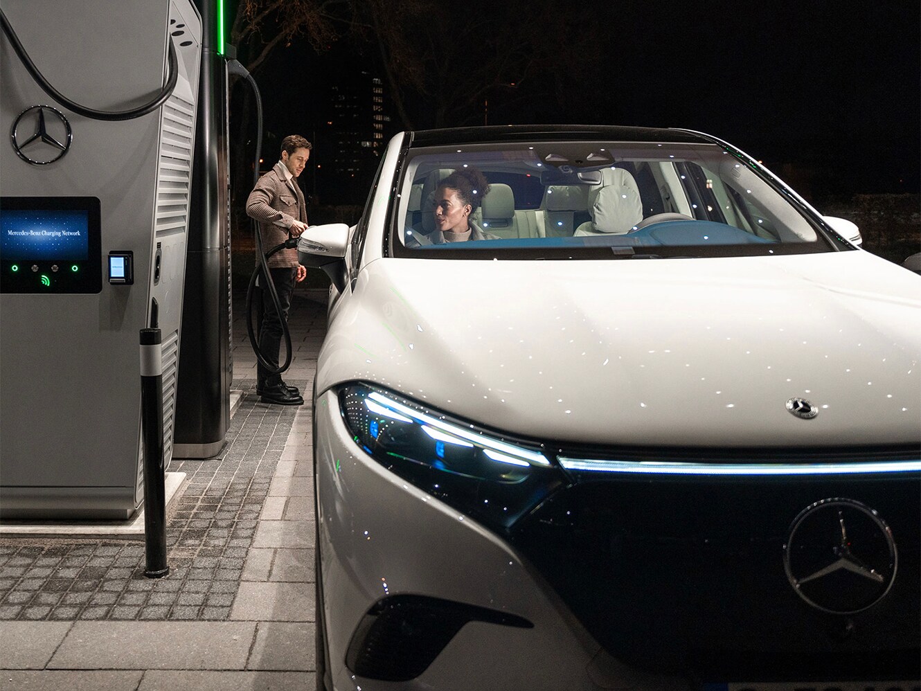 Un hombre cargando un EQE en una estación de carga